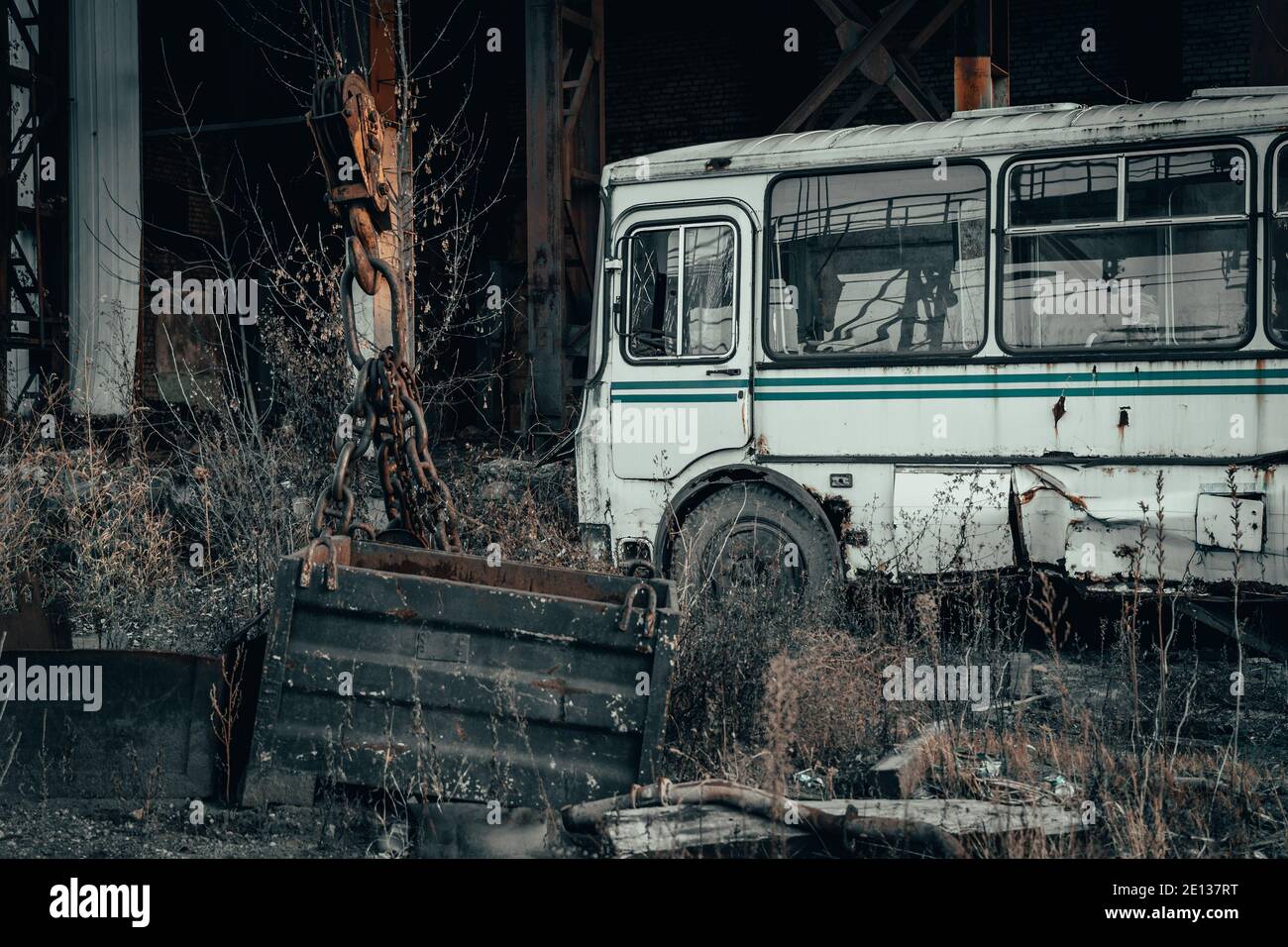 Vecchio retro arrugginito rotto autobus abbandonato in oscuro industriale post apocalittico paesaggio. Foto Stock