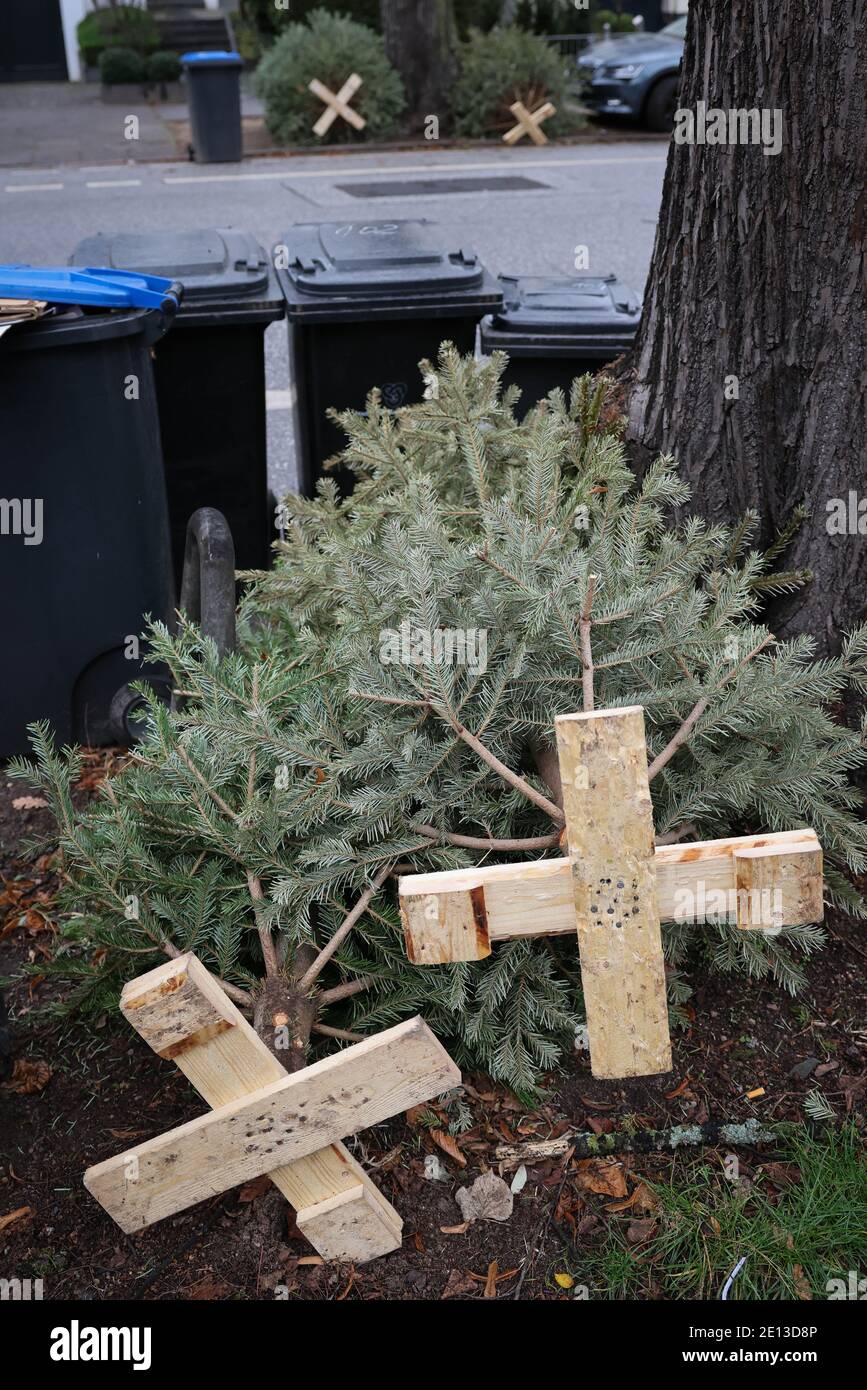 Amburgo, Germania. 4 gennaio 2021. Gli alberi di Natale con un supporto in legno inchiodato si trovano sul lato della strada. Credit: Christian Charisius/dpa/Alamy Live News Foto Stock