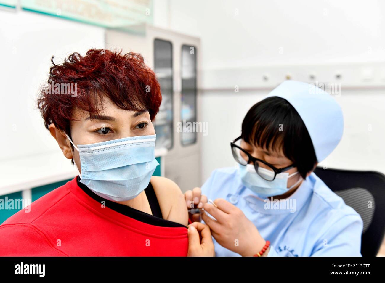 (210104) -- JINAN, 4 gennaio 2021 (Xinhua) -- UN medico inocula un ricevente con un vaccino COVID-19 in un ospedale a Jinan, nella provincia di Shandong, nella Cina orientale, 4 gennaio 2021. Un totale di 217,158 dosi di vaccini COVID-19 sono state somministrate a gruppi chiave con maggiori rischi di infezione nella provincia di Shandong, nella Cina orientale, ha detto lunedì. A partire da domenica, non sono stati segnalati effetti collaterali gravi tra i destinatari del vaccino, ha detto la commissione sanitaria provinciale. Secondo la commissione, gli ispettori doganali di prima linea coinvolti nell'importazione di merci congelate e nel carico e tra Foto Stock