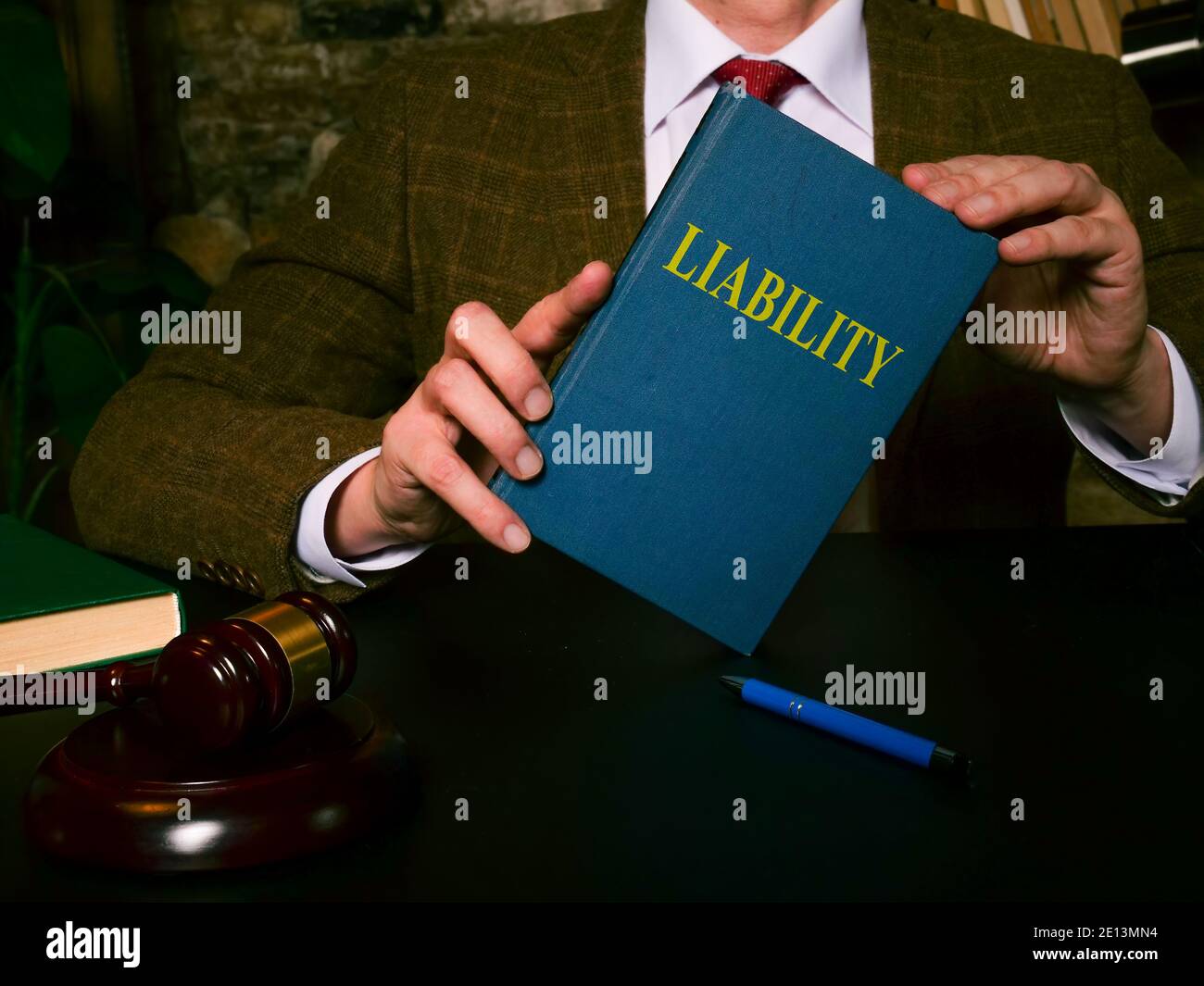 L'avvocato al tavolo mostra una legge di responsabilità del libro. Foto Stock