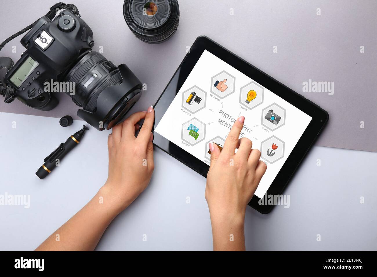 Giovane fotografo con un computer tablet che utilizza un programma di mentoring, vista dall'alto Foto Stock