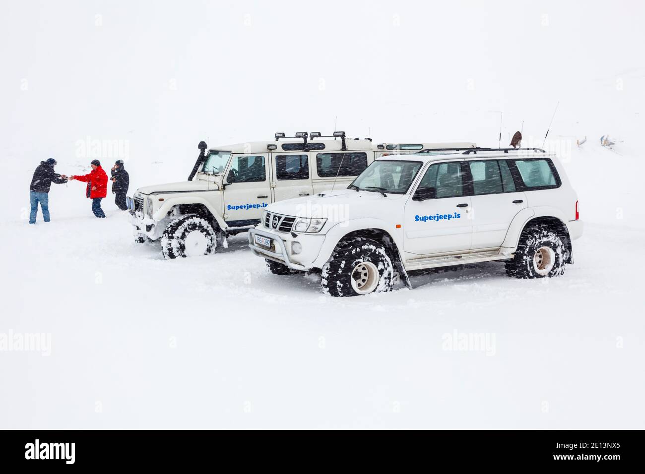 Veicoli bianchi Land Rover Defender 4v4 4WD parcheggiati in condizioni di lavoro gravose Neve in un'escursione turistica in Islanda Foto Stock