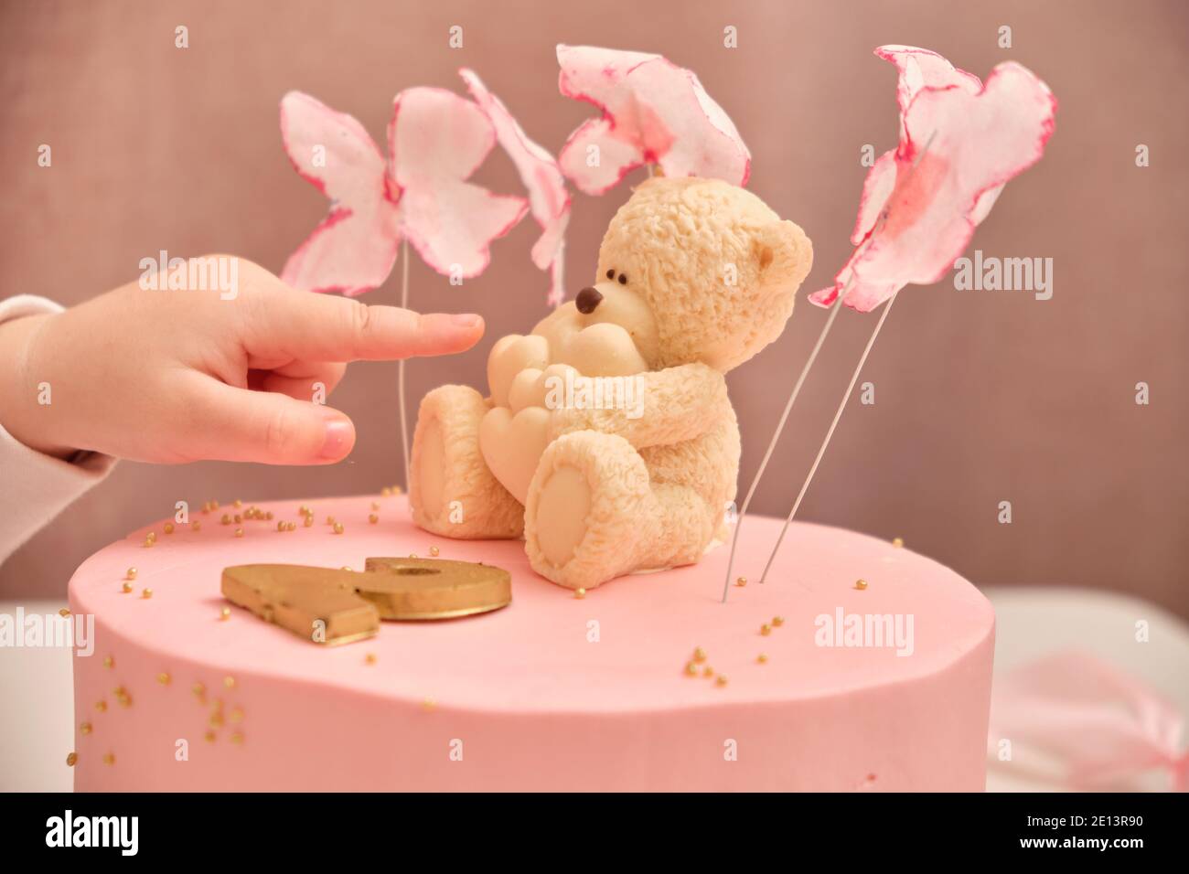 Torta di compleanno rosa rotonda per un bambino di 2 anni. Orsetto di  cioccolato bianco con cuori sulla torta Foto stock - Alamy