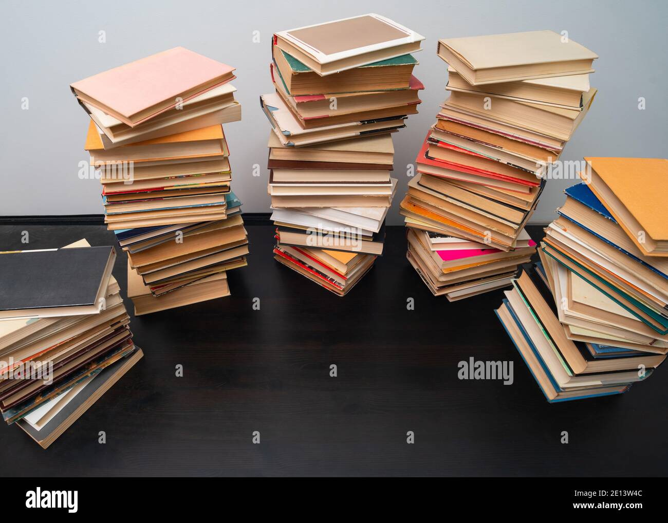 Grande pila di libri sul tavolo. Studiare prima dell'esame. Pila di libri d'epoca. Concetto di istruzione e di studio Foto Stock