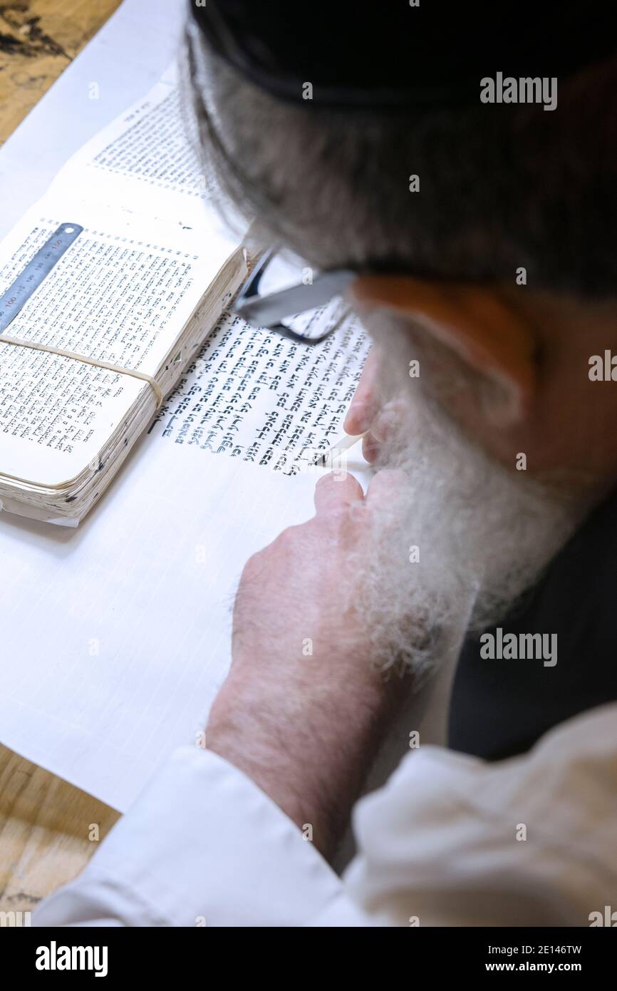 Primo piano foto di uno scriba rabbino che scrive un rotolo di Torah. A Brooklyn, New York City. Foto Stock