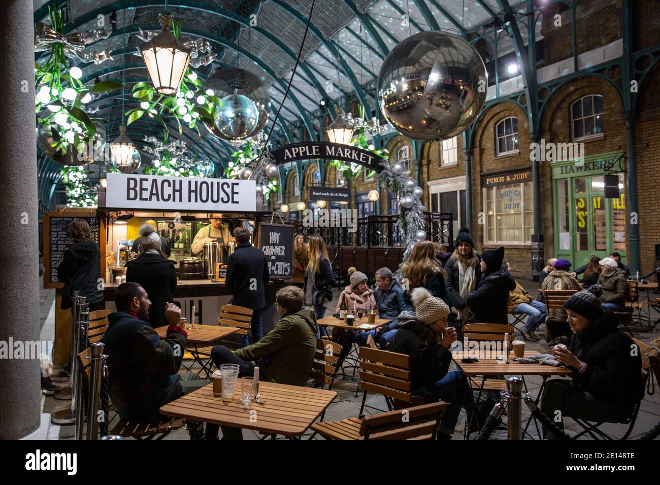 Gli acquirenti di Natale si siedono e portano via un caffè socialmente distanziato nella Covent Garden Piazza durante le misure di Lockdown di Tier2 Coronavirus, Londra UK Foto Stock