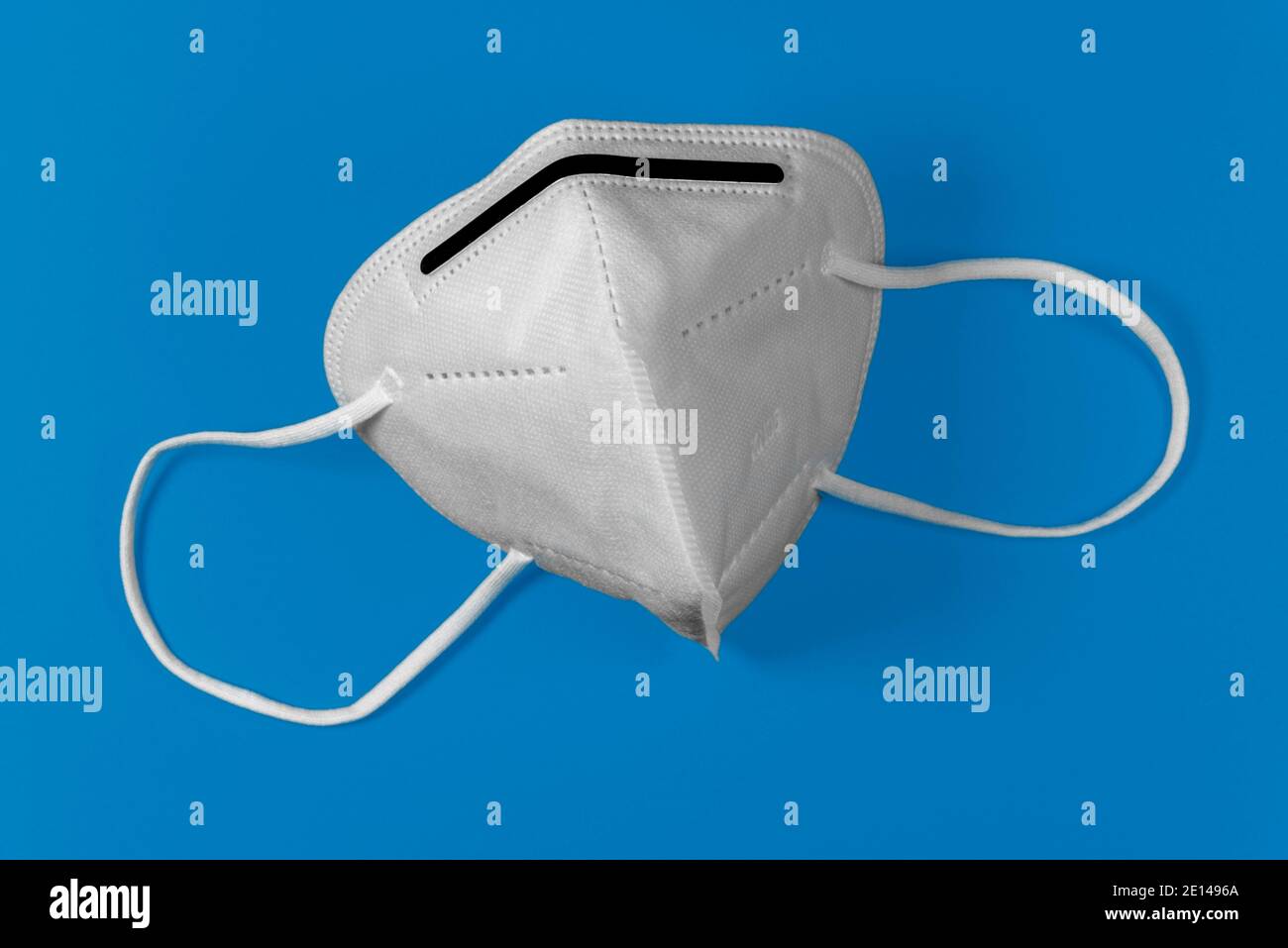 Maschera bianca KN95 o FFP2 su sfondo blu. Maschera medica per la protezione Covid-19 per prevenire la pandemia del coronavirus Foto Stock