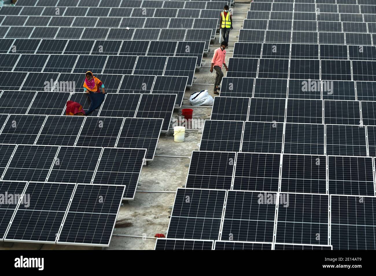 Gazipur. 4 gennaio 2021. I tecnici installano pannelli solari su una fabbrica di Gazipur, alla periferia della capitale Dhaka, Bangladesh, il 3 gennaio 2021. Oggi i sistemi solari stanno diventando una forma sempre più popolare di energia alternativa in Bangladesh, e molte fabbriche nel paese stanno passando ai sistemi di energia solare. Credit: Xinhua/Alamy Live News Foto Stock