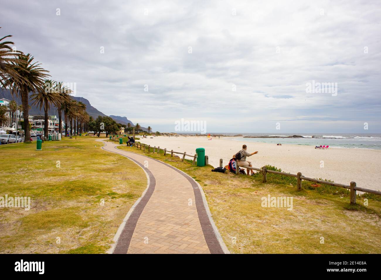 Camps Bay- Città del Capo, Sud Africa - 23/11/2020 Camps Bay Boardwalk in un caldo, pomeriggio coperto. Uomo e donna che conversano sulla ringhiera in legno. Foto Stock Camps Bay- Città del Capo, Sud Africa - 23/11/2020 Camps Bay Boardwalk in un caldo, pomeriggio coperto. Uomo e donna che conversano sulla ringhiera in legno. Foto Stock
