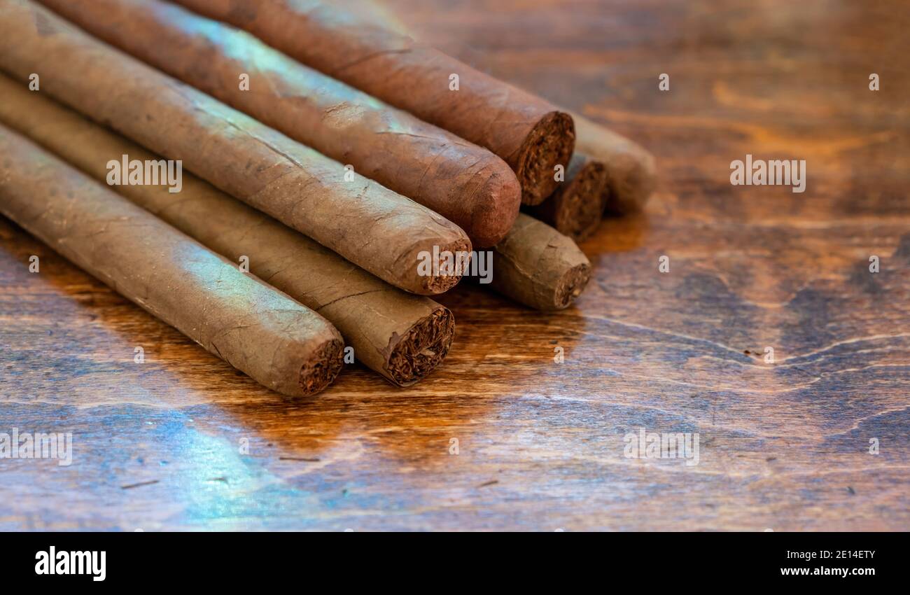 Sigari su un tavolo di legno, vista guardaroba. Assortimento di sigari fatti a mano di qualità cubana, fumo di tabacco stile di vita di lusso. Foto Stock