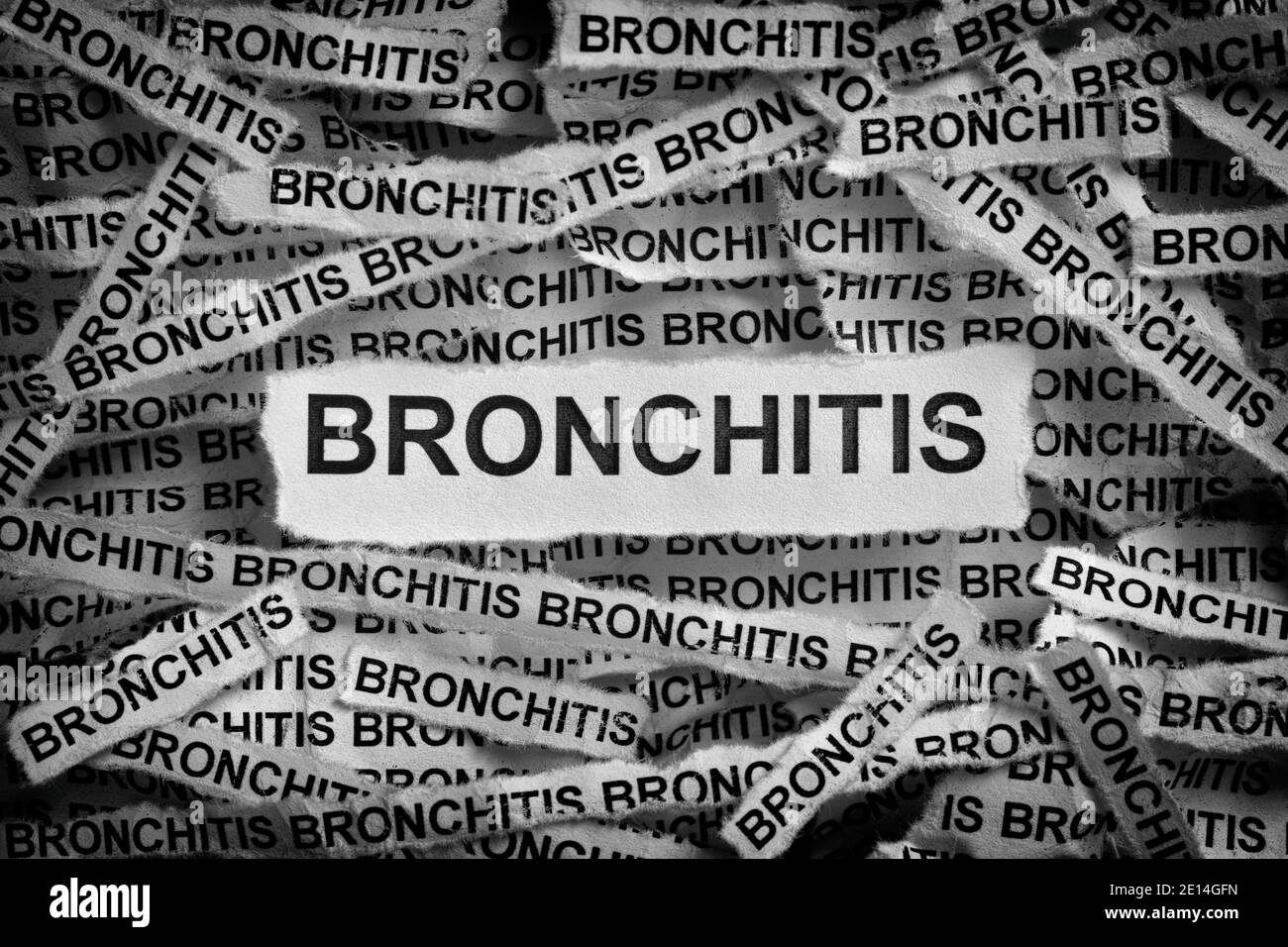 Bronchite. Strappato pezzi di carta con la parola bronchite. Bianco e nero. Primo piano. Foto Stock