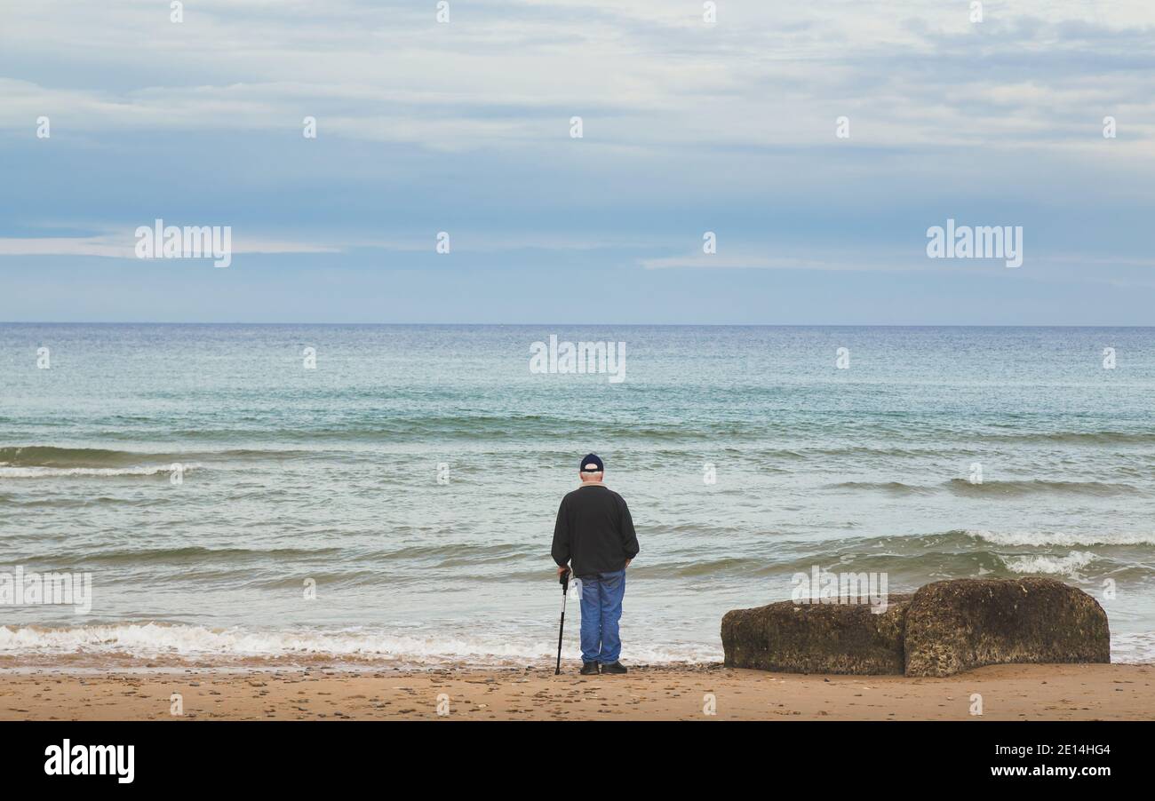 Normandia, Francia - 3 novembre 2015: Un veterano di guerra ha un momento di riflessione su Utah Beach, uno dei siti degli sbarchi del D-Day durante il secondo W. Foto Stock