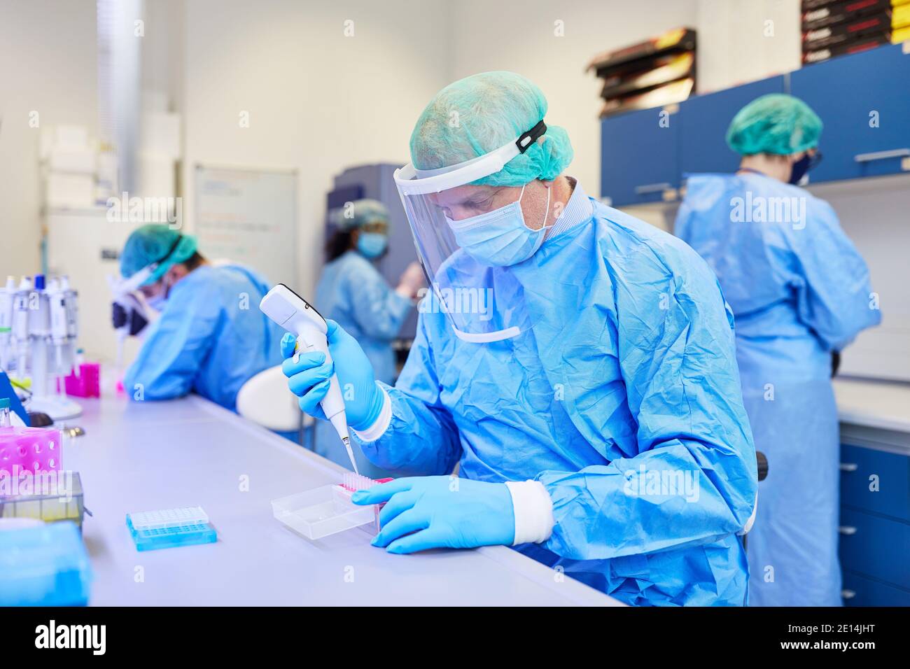Il team medico analizza insieme i campioni di test Covid-19 in laboratorio durante la pandemia del coronavirus Foto Stock