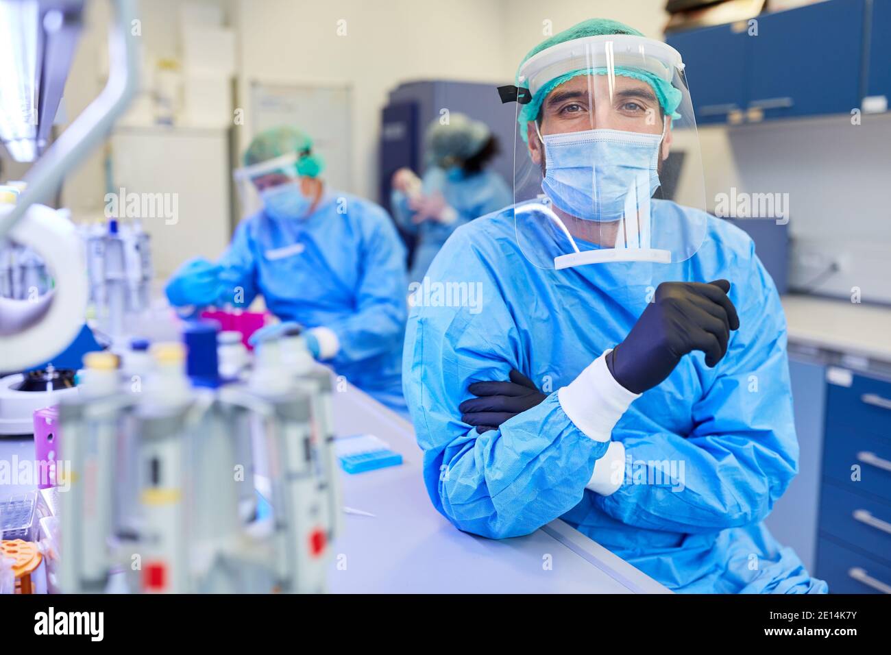 Uomo come ricercatore in abbigliamento protettivo in laboratorio a. Covid-19 ricerca sul vaccino nella pandemia del coronavirus Foto Stock
