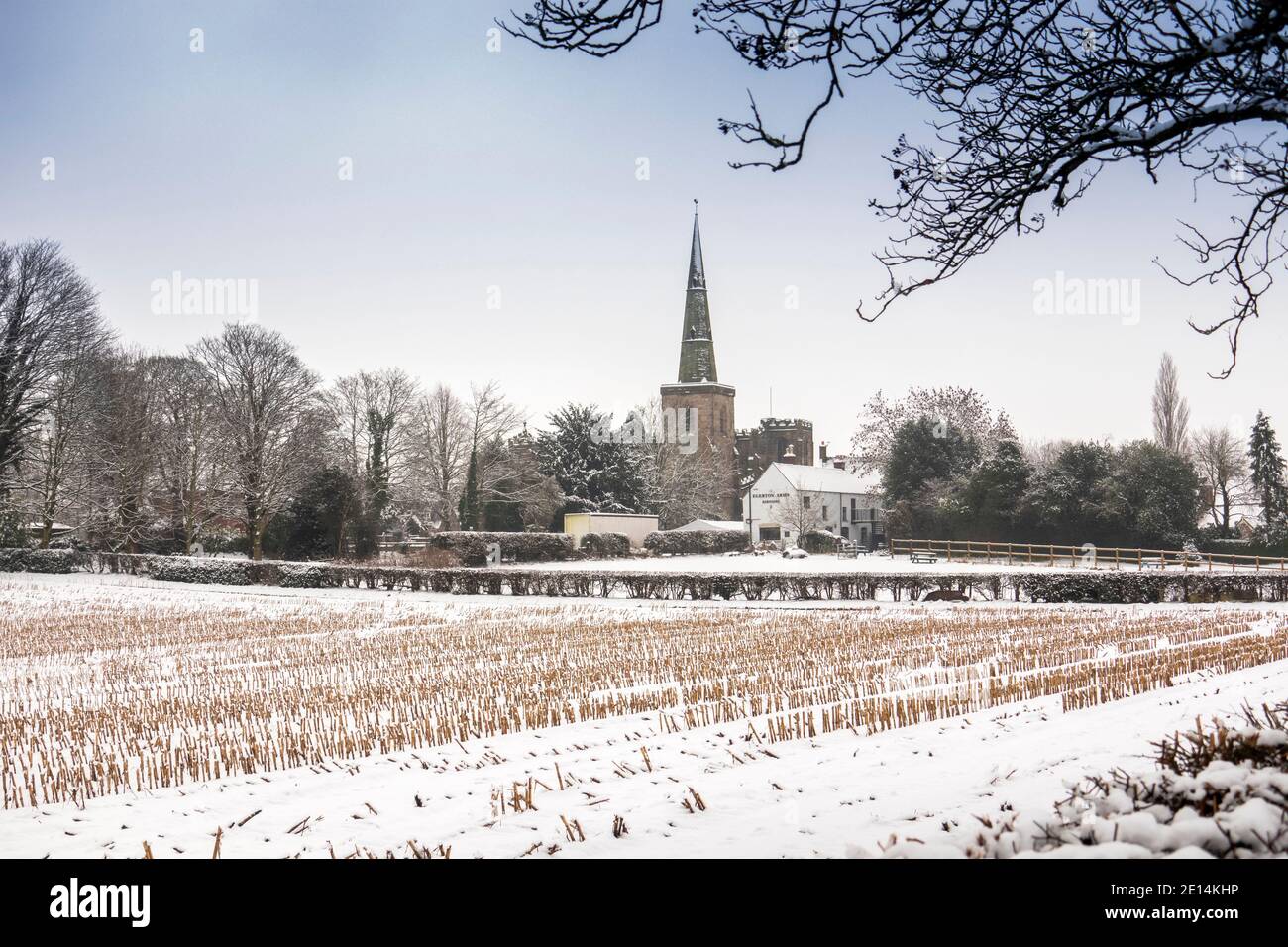 Regno Unito, Inghilterra, Cheshire, Congleton, Astbury, Village e St Mary’s Church in inverno, attraverso i campi agricoli Foto Stock