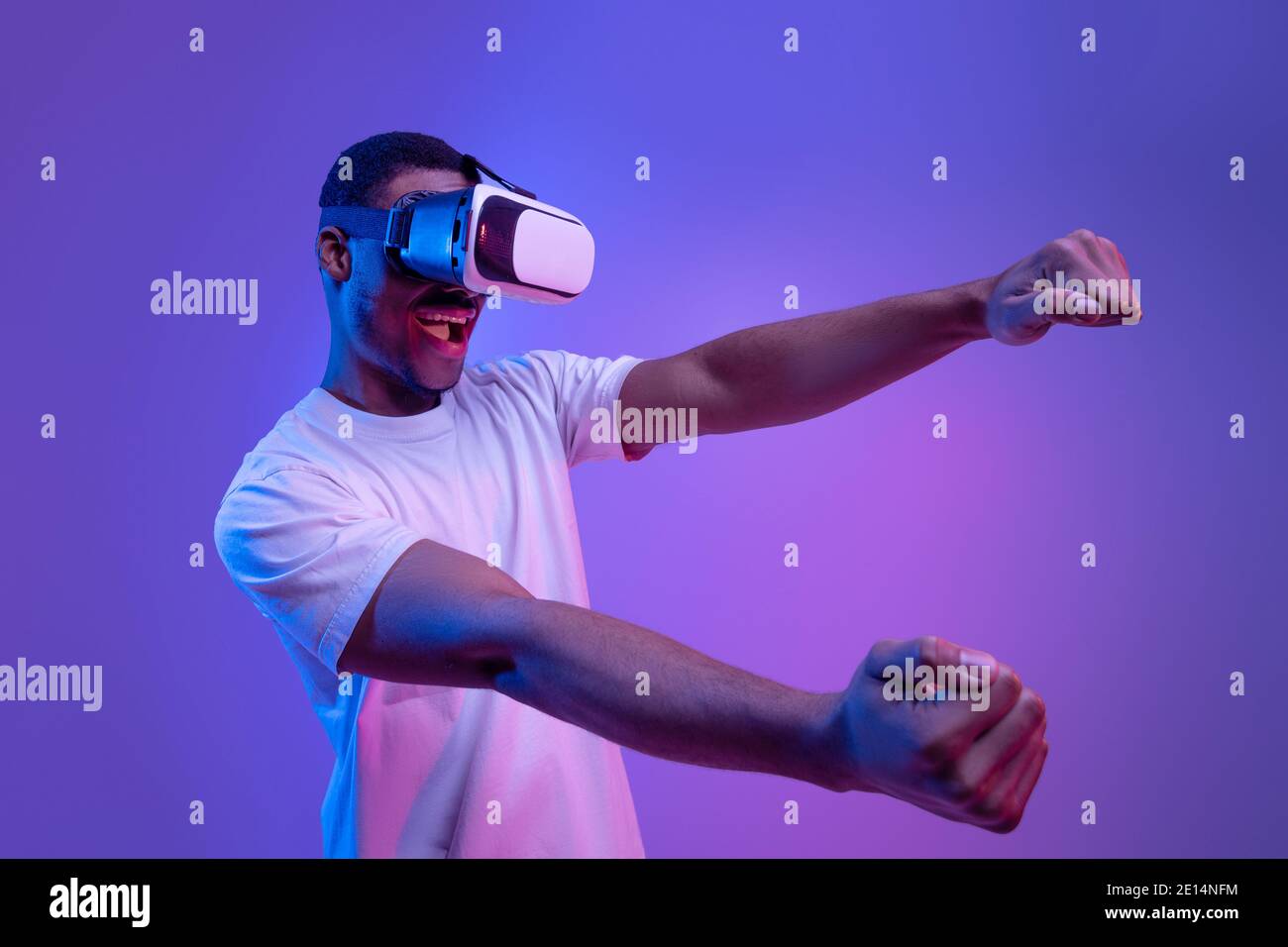 Gioco moderno. Black Man in occhiali VR vivere la realtà virtuale, Neon Lighting Foto Stock