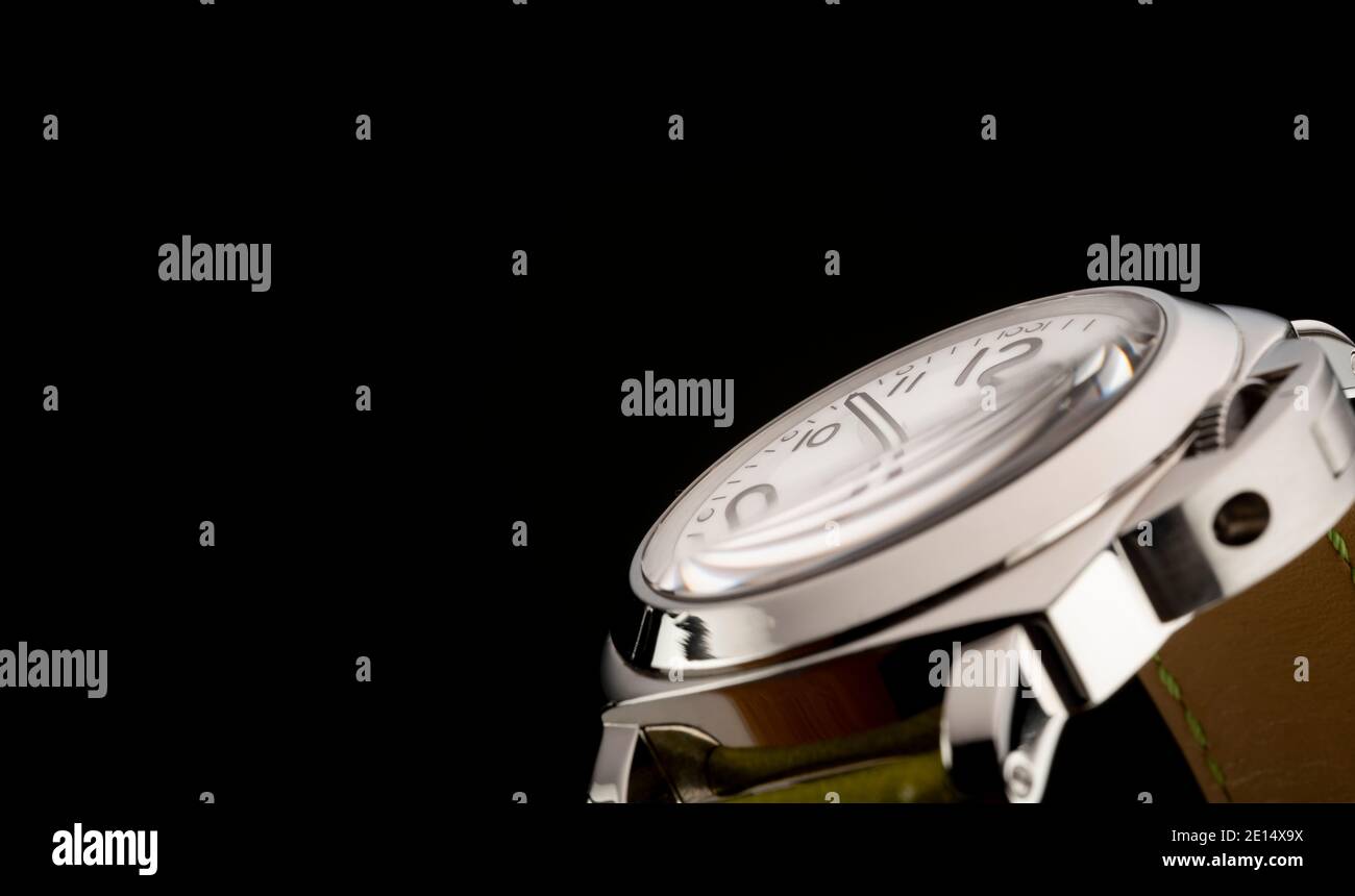 Un orologio luminor Officine Panerai con cinturino verde fotografato su sfondo nero. Foto Stock