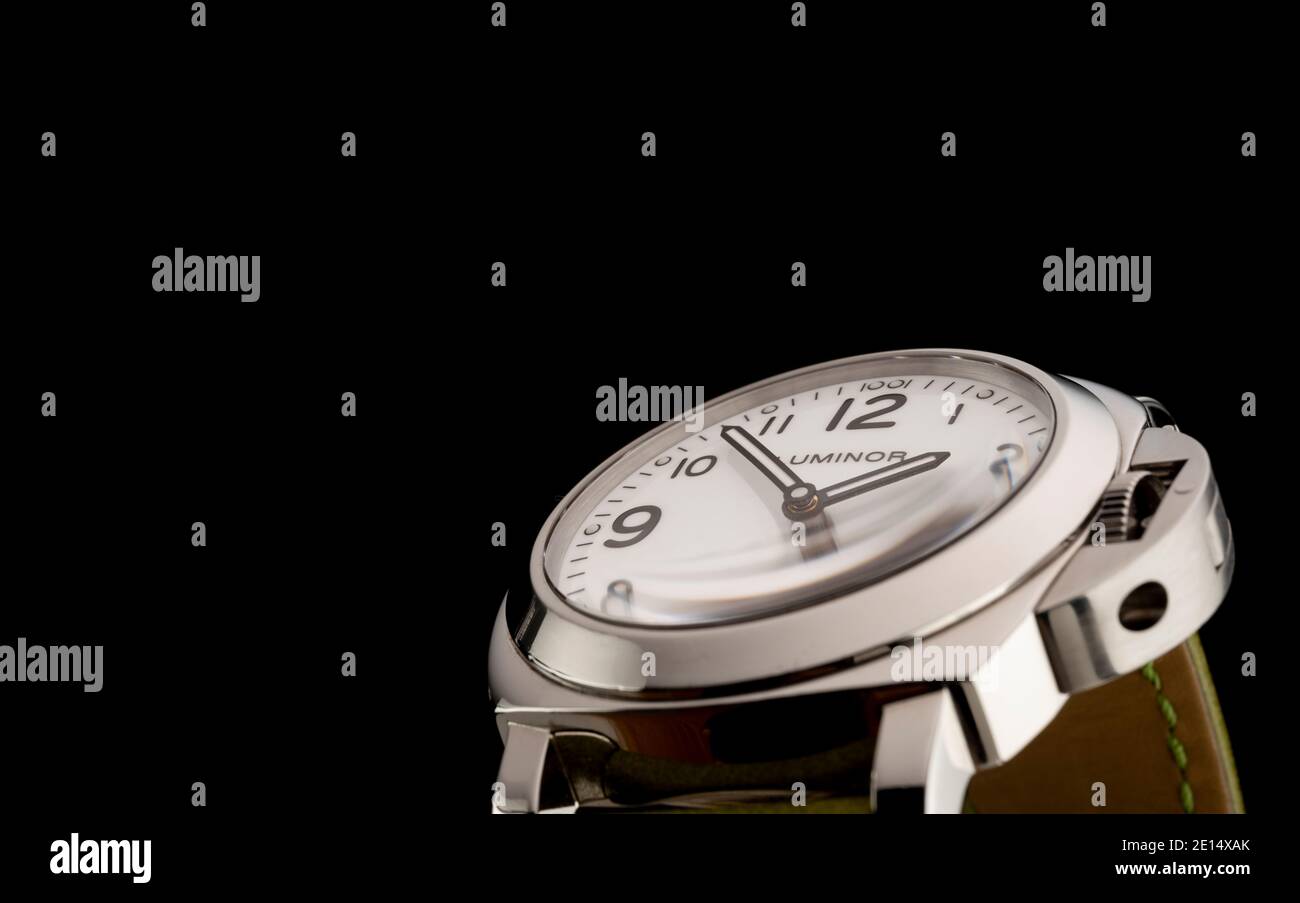 Un orologio luminor Officine Panerai con cinturino verde fotografato su sfondo nero. Foto Stock