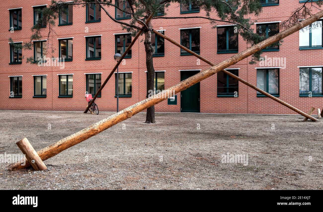 La posta di legno sostiene UN albero nella città Foto Stock