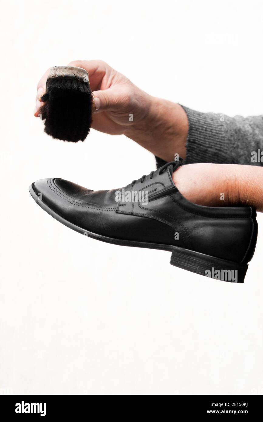 Cura delle scarpe in pelle. Pulizia scarpe in pelle con crema per scarpe nera Foto Stock
