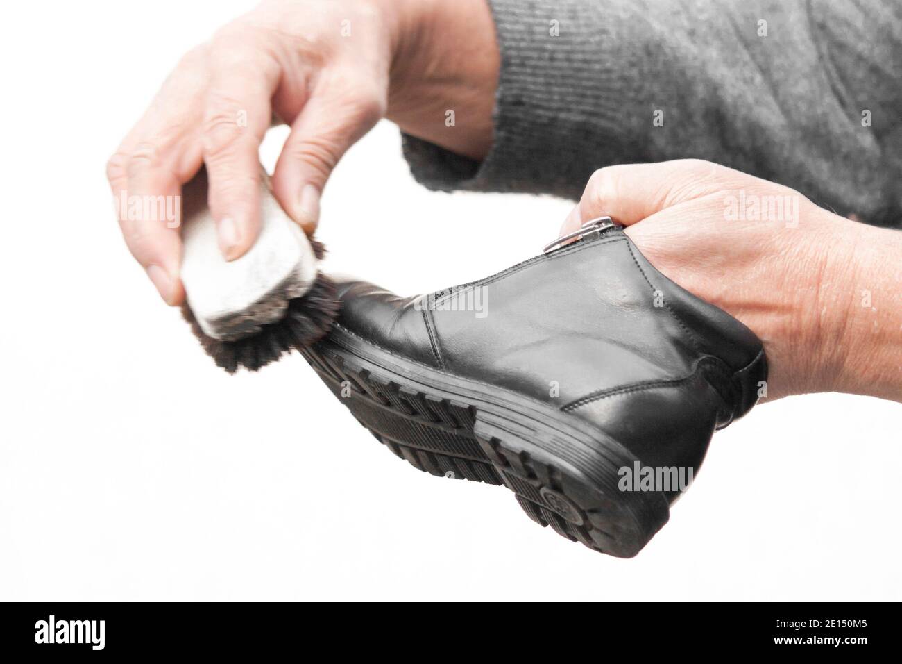 Cura delle scarpe in pelle. Pulizia scarpe in pelle con crema per scarpe nera Foto Stock