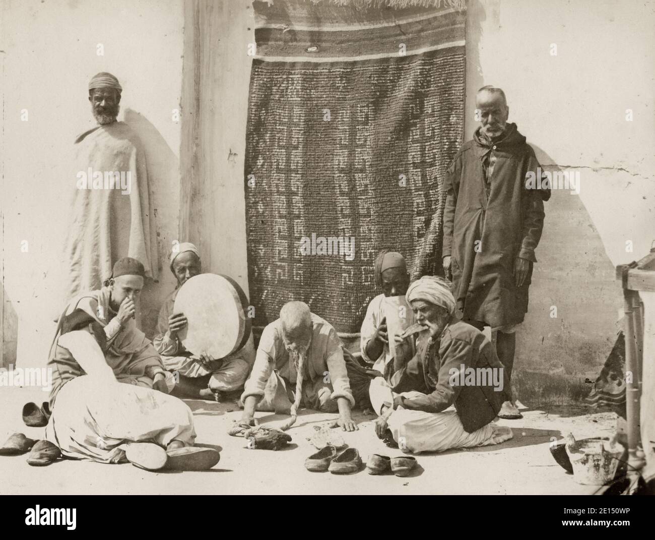 Fotografia d'epoca del XIX secolo - uomini di Isawiyya, Algeri, Algeria. È una fratellanza mistica islamica religiosa fondata a Meknes, Marocco, dallo sceicco al-Kamil Mohamed al-Hadi ben Issa. Sono noti per la loro musica spirituale, che generalmente comprende canti di salmi religiosi, caratterizzati dall'uso dell'oboe ghaita (simile al mizmar o zurna) accompagnato da percussioni con il polithythm. Foto Stock