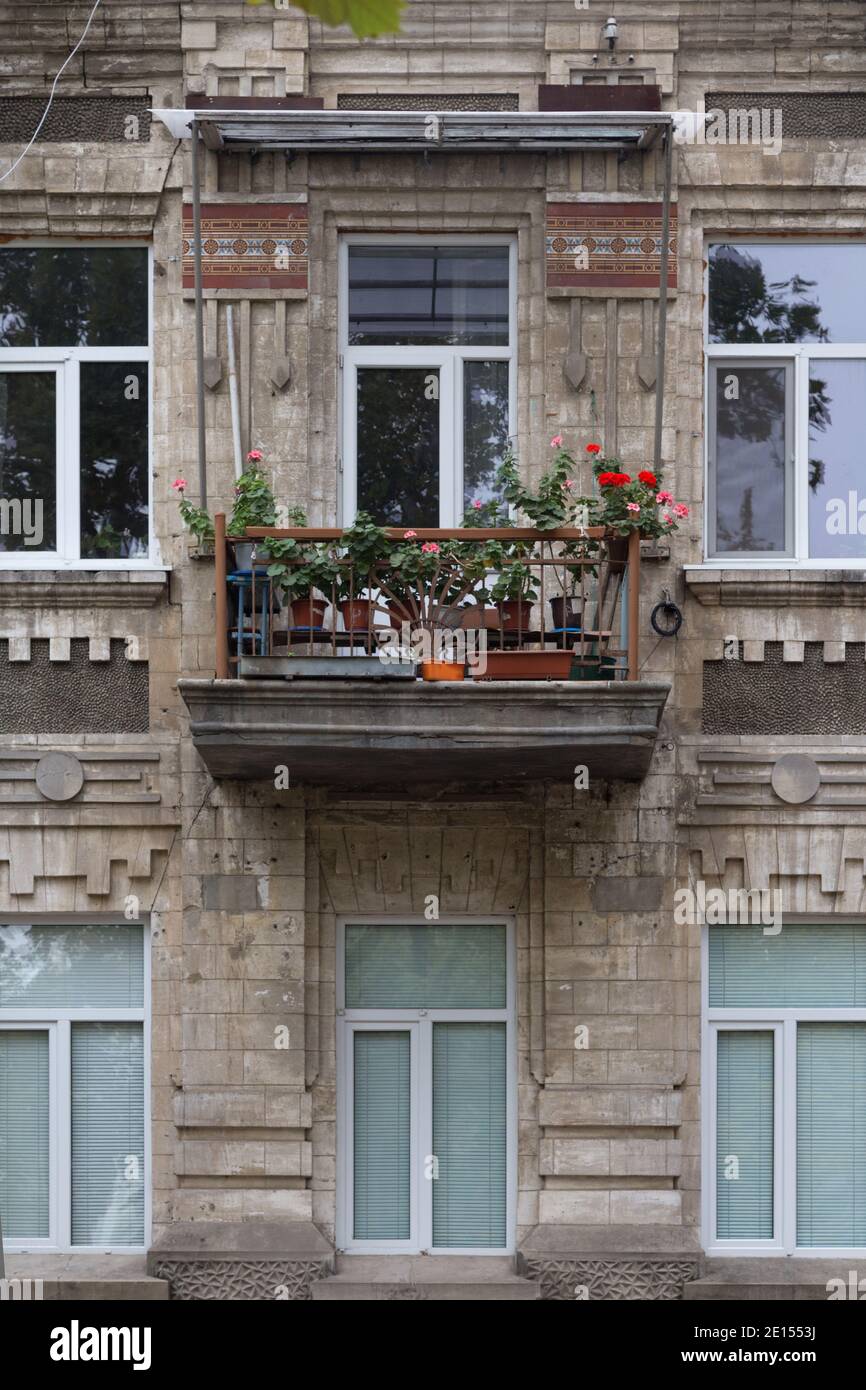 La facciata di una vecchia casa con fiori sul balcone. Casa il 31 agosto 1991 strada a Chisinau, Repubblica di Moldavia. Foto Stock