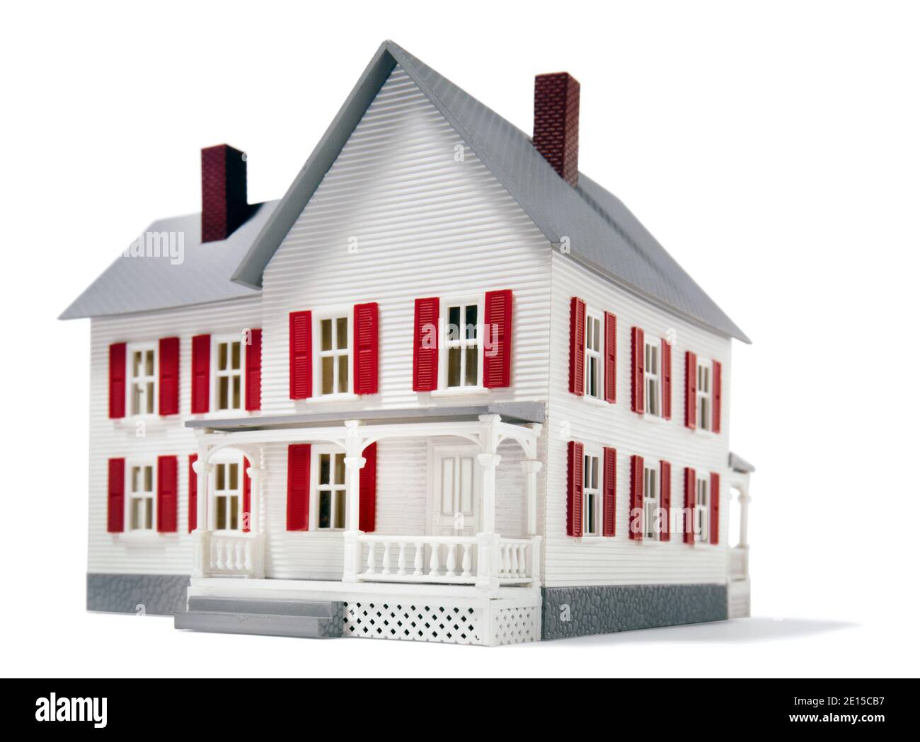 Casa giocattolo bianca con persiane rosse e portico fotografato uno sfondo bianco Foto Stock