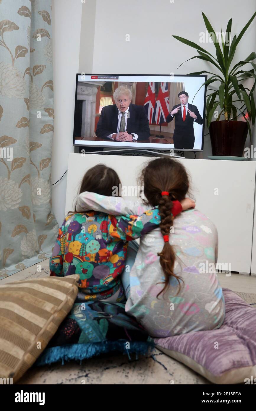 Chichester, West Sussex, Regno Unito. Firenze, 5, (a sinistra) e sua sorella Isabelle, 8, (a destra) guardando il primo ministro britannico Boris Johnson che ha pronunciato il suo discorso alle 20:00 lunedì 4 gennaio 2021 mettendo il Regno Unito in esso è 3 ° Lockdown e chiudere le scuole. Credit: Sam Stephenson/Alamy Live News Foto Stock