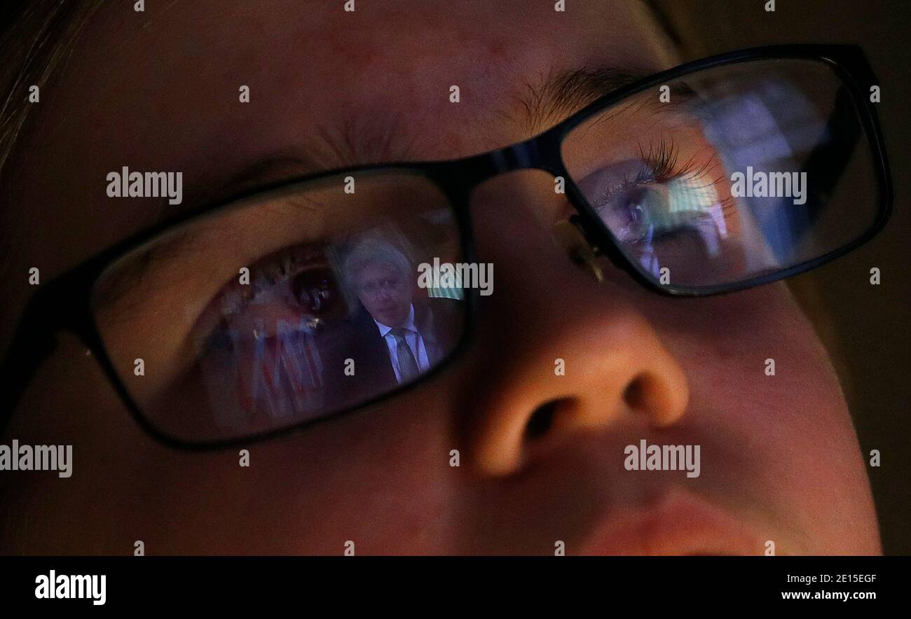 Loughborough, Leicestershire, Regno Unito. 4 gennaio 2021. Una ragazza guarda una trasmissione dal vivo dal primo ministro BritainÕs Boris Johnson mentre annuncia un blocco nazionale dopo un grande aumento dei casi di coronavirus. Credit Darren Staples/Alamy Live News. Foto Stock