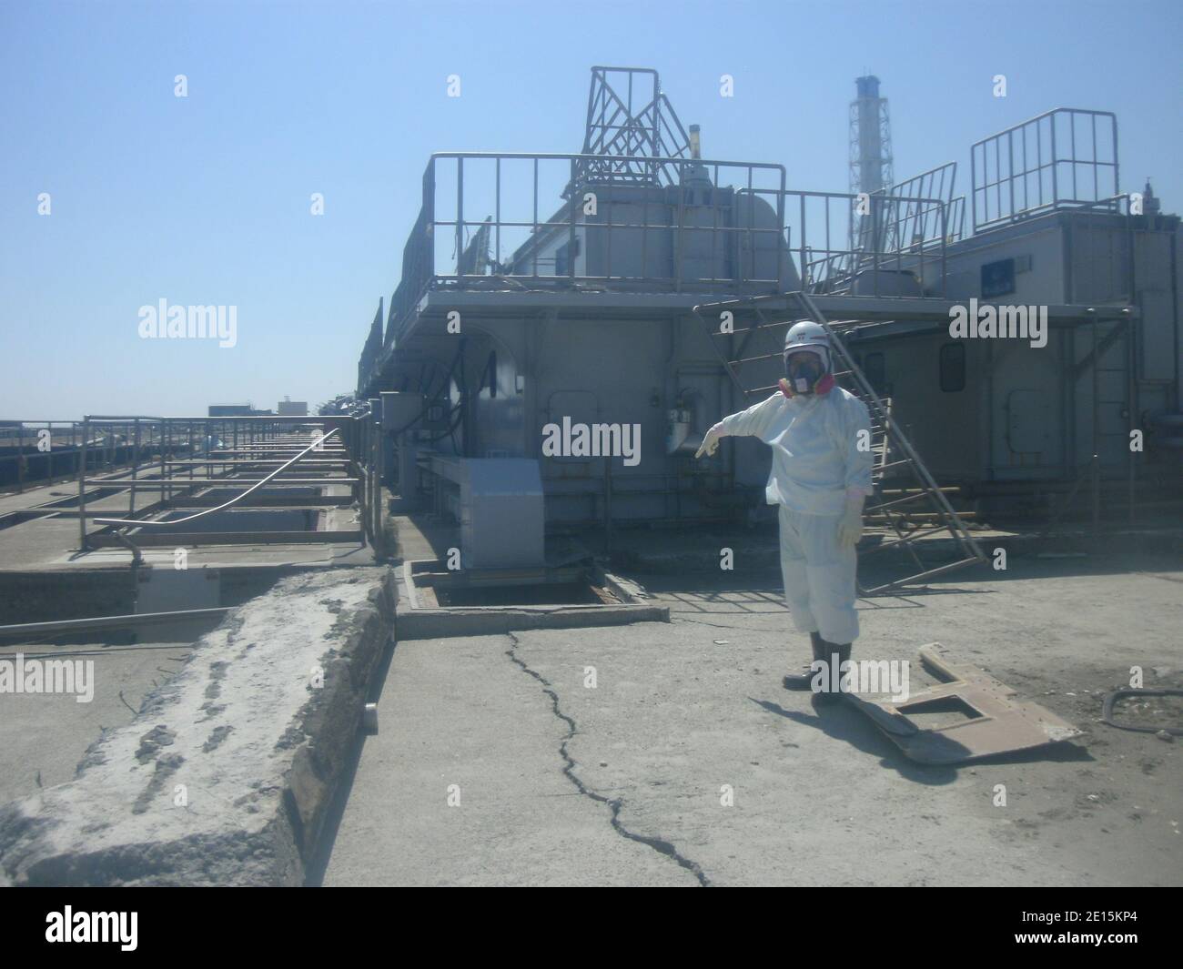 Un operaio che indossa una tuta protettiva punta in una fossa di cemento fessurato vicino al suo reattore n. 2 della centrale nucleare Fukushima Daiichi di Tokyo Electric Power Co. (TEPCO) nella prefettura di Fukushima, Giappone, 2 aprile 2011. L'operatore della centrale nucleare giapponese colpita ha detto il sabato che aveva trovato l'acqua radioattiva che fuoriesce in mare da una fossa di calcestruzzo fessurata nel suo reattore n. 2 a Fukushima. TEPCO ha detto che la radiazione nella buca misurava 1,000 millidi all'ora. Foto tramite ABACAPRESS.COM Foto Stock