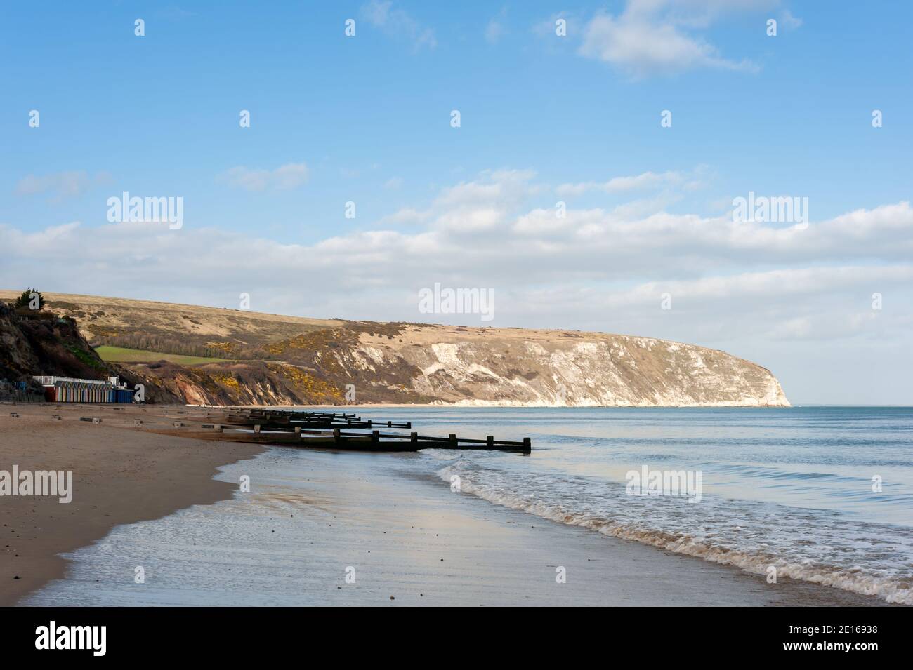 SWANAGE, DORSET, Regno Unito - 14 MARZO 2009: Vista lungo una spiaggia tranquilla verso le scogliere Foto Stock