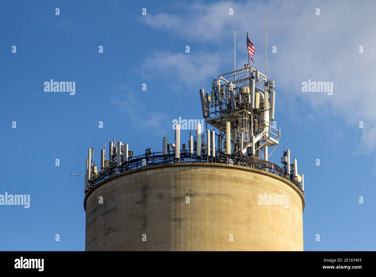 La tradizione incontra la tecnologia. 5G cellulare torre sulla cima di un vecchio fienile silo. Foto Stock