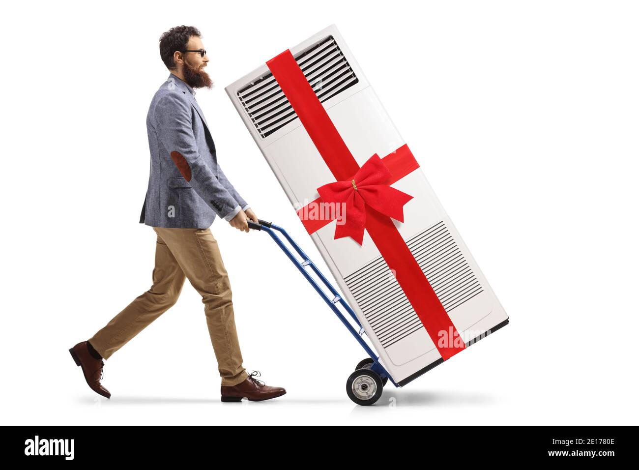 Scatto di profilo di lunghezza intera di un uomo bearded che spinge a. carrello a mano con condizionatore d'aria portatile collegato con un nastro rosso isolato su sfondo bianco Foto Stock