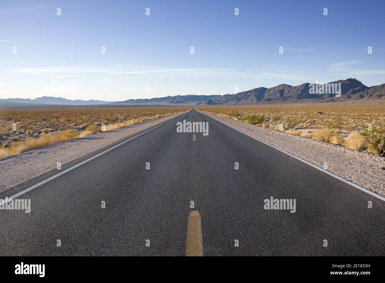 La strada vuota attraversa il deserto del Mojave in California Foto Stock