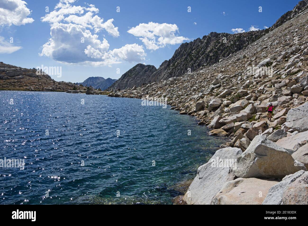 Donna escursioni intorno al bordo del Lago d'Oro nel Montagne della Sierra Nevada Foto Stock