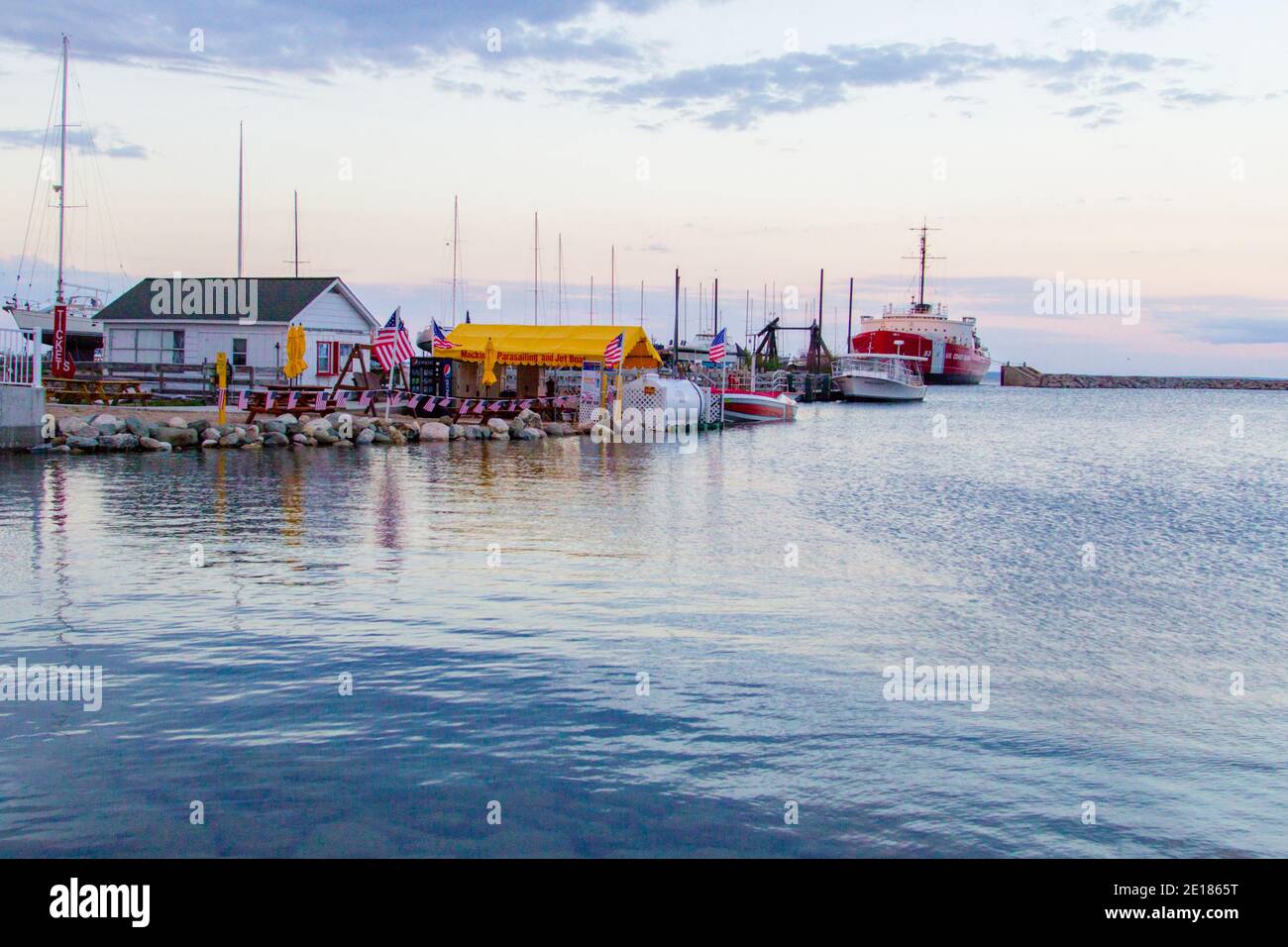 Mackinaw City, Michigan, USA - 29 maggio 2020: Barche da diporto e barche a vela si affacciano sul porto e sul porticciolo al tramonto nel piccolo villaggio costiero Foto Stock