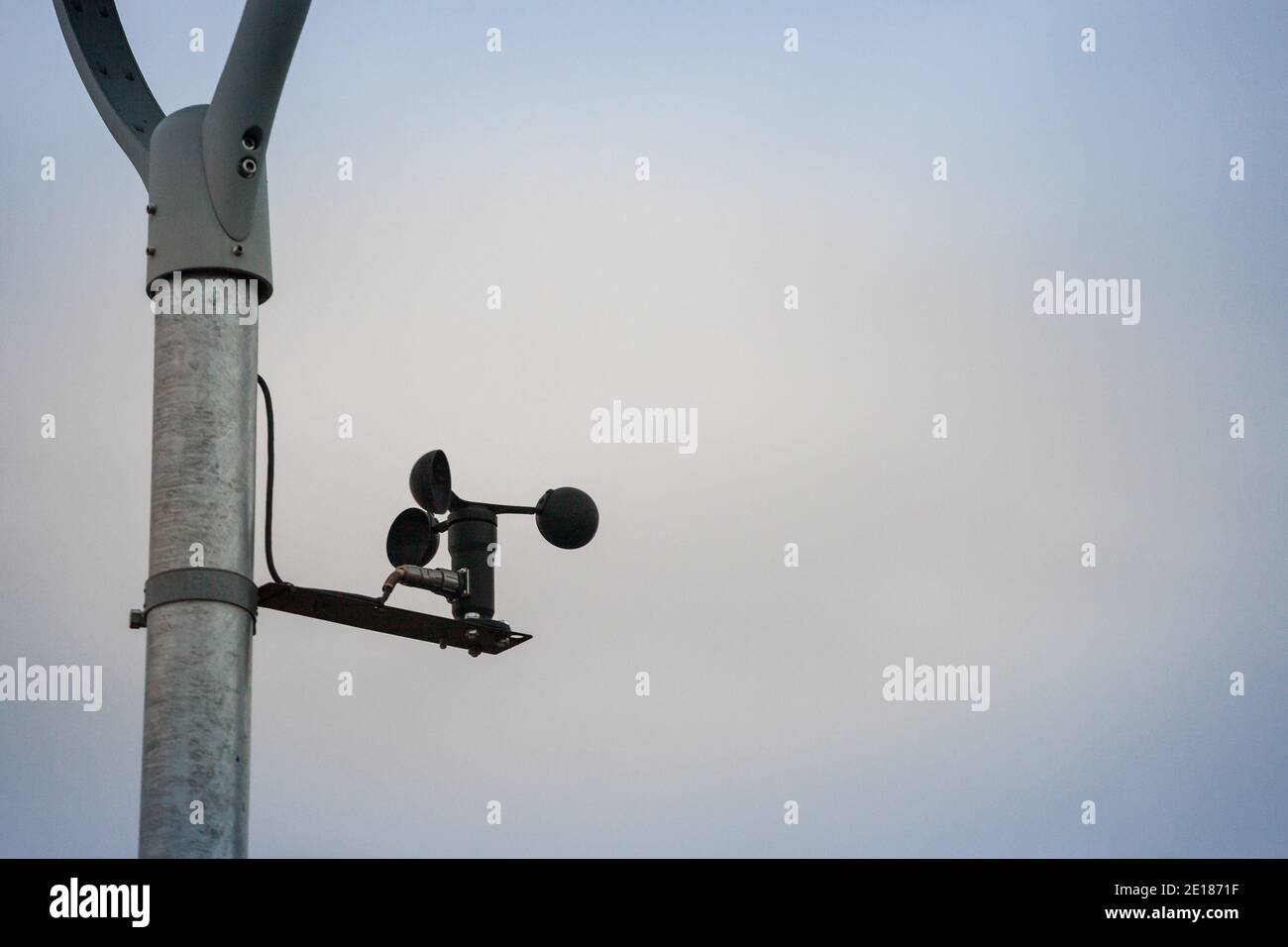 Anemometro che gira e gira nel vento di fronte a un clima grigio nuvoloso. Un anemometro viene utilizzato in meteorologia per misurare la velocità del vento. Pi Foto Stock