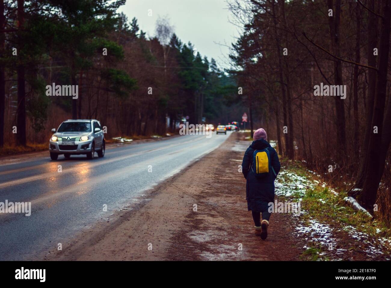 Persona che cammina via lungo una strada di campagna in un giorno umido autunno, regione di Mosca, 29.12.2020 Foto Stock