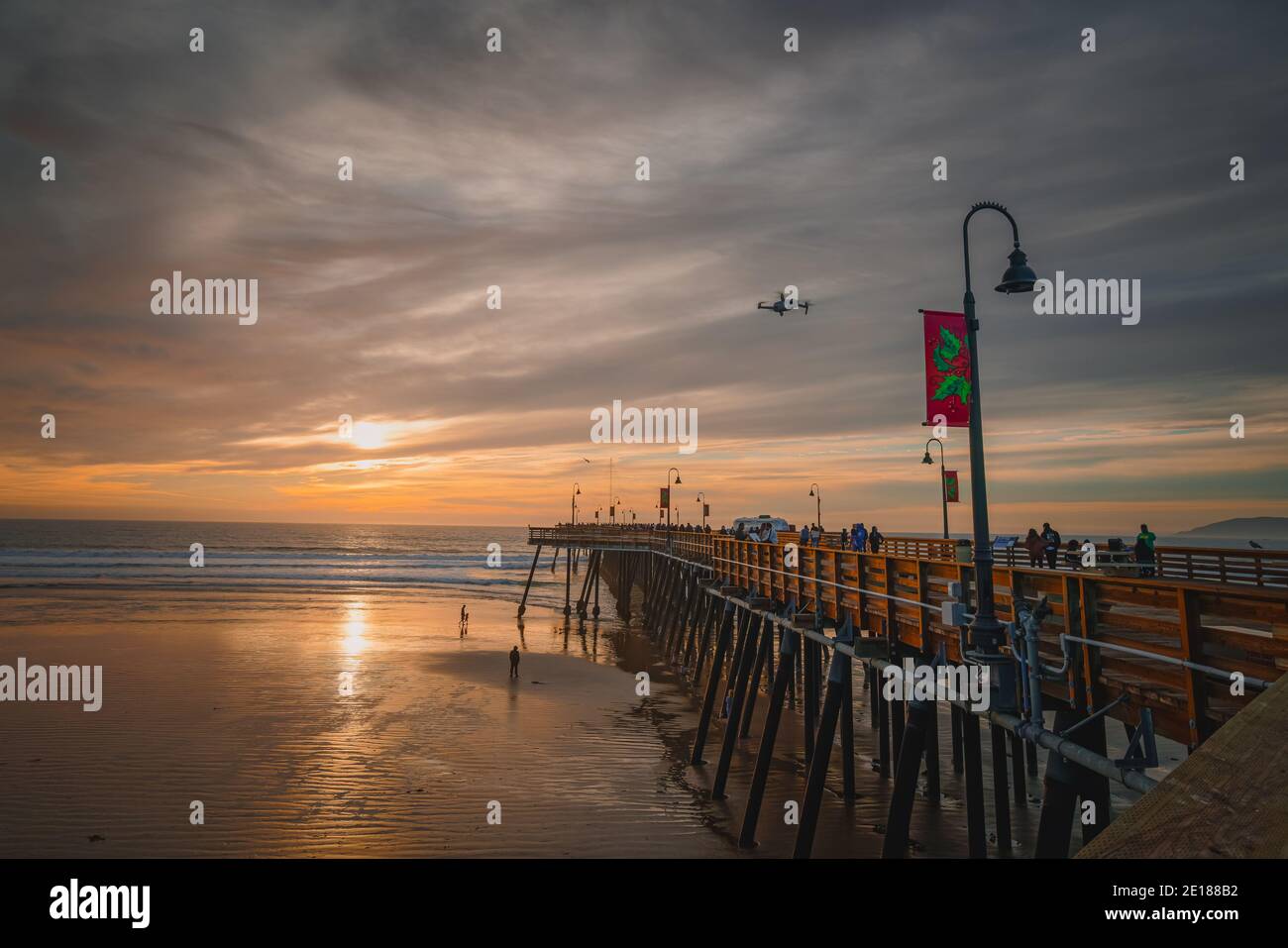 Pismo Beach, California, USA - 1 gennaio 2021 Tramonto sulla spiaggia e sul molo. Un iconico molo in legno della California lungo 370 metri nel cuore del Pismo Foto Stock