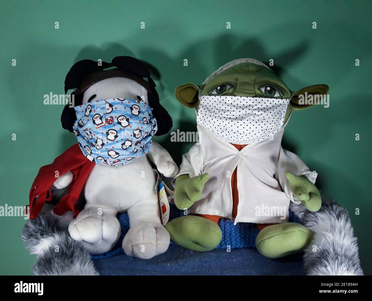 Teddy orso ripieno animale Snoopy da cartone animato e bambino Yoda dal film star wars che indossa maschere facciali durante la pandemia covid-19 del 2020 Foto Stock