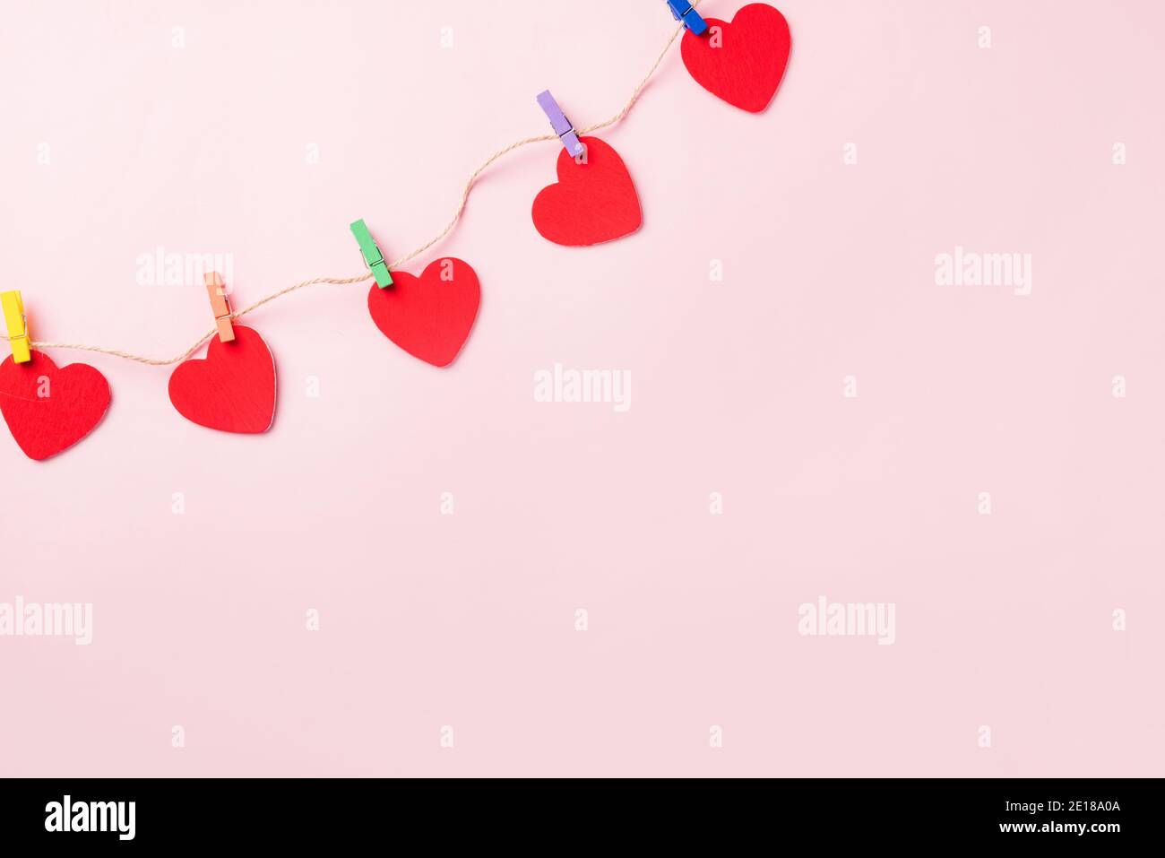 Buon San Valentino sfondo giorno. Cuore rosso decorazione valentine a forma di cuore appeso con graffette sulla corda per amore composizione biglietto di auguri isola Foto Stock