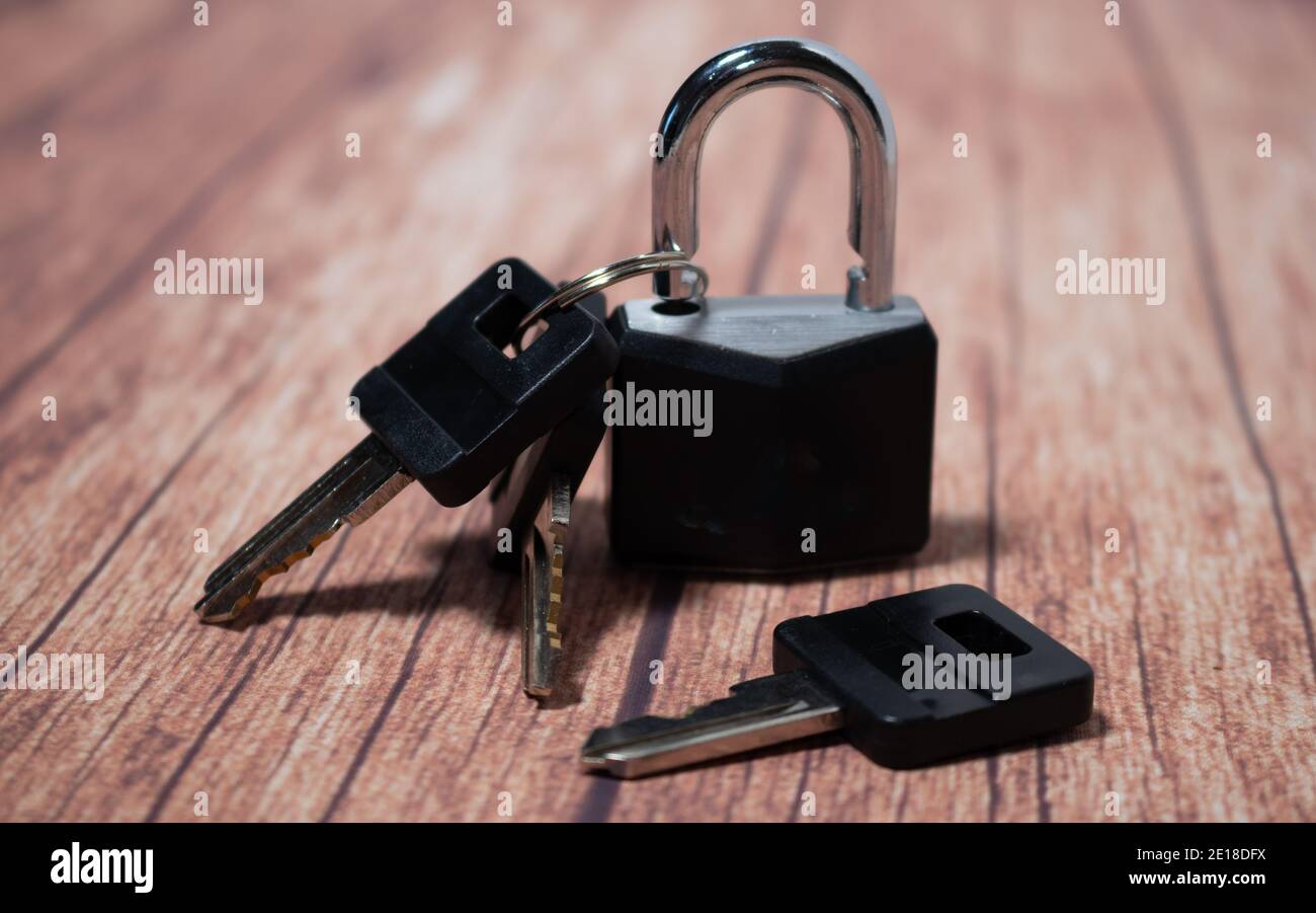 Lucchetto nero molto sicuro con chiavi su fondo di legno. Concetto di  sicurezza e tranquillità Foto stock - Alamy