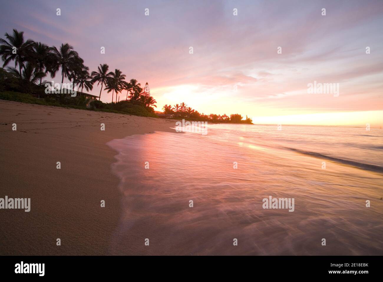 Sunset on Waialua Beach, with calm waves in foreground Foto Stock