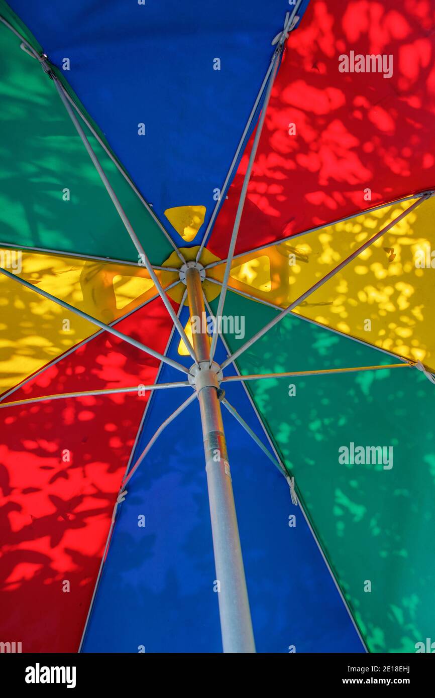 Una vista dal basso di un ombrello colorato, traslucido con ombre Foto Stock