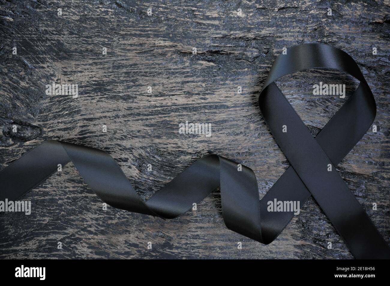 Vista dall'alto del nastro nero su sfondo di legno scuro con spazio per la copia. Melanoma o cancro della pelle, prevenzione delle bande e concetto di consapevolezza della narcolessia. Foto Stock