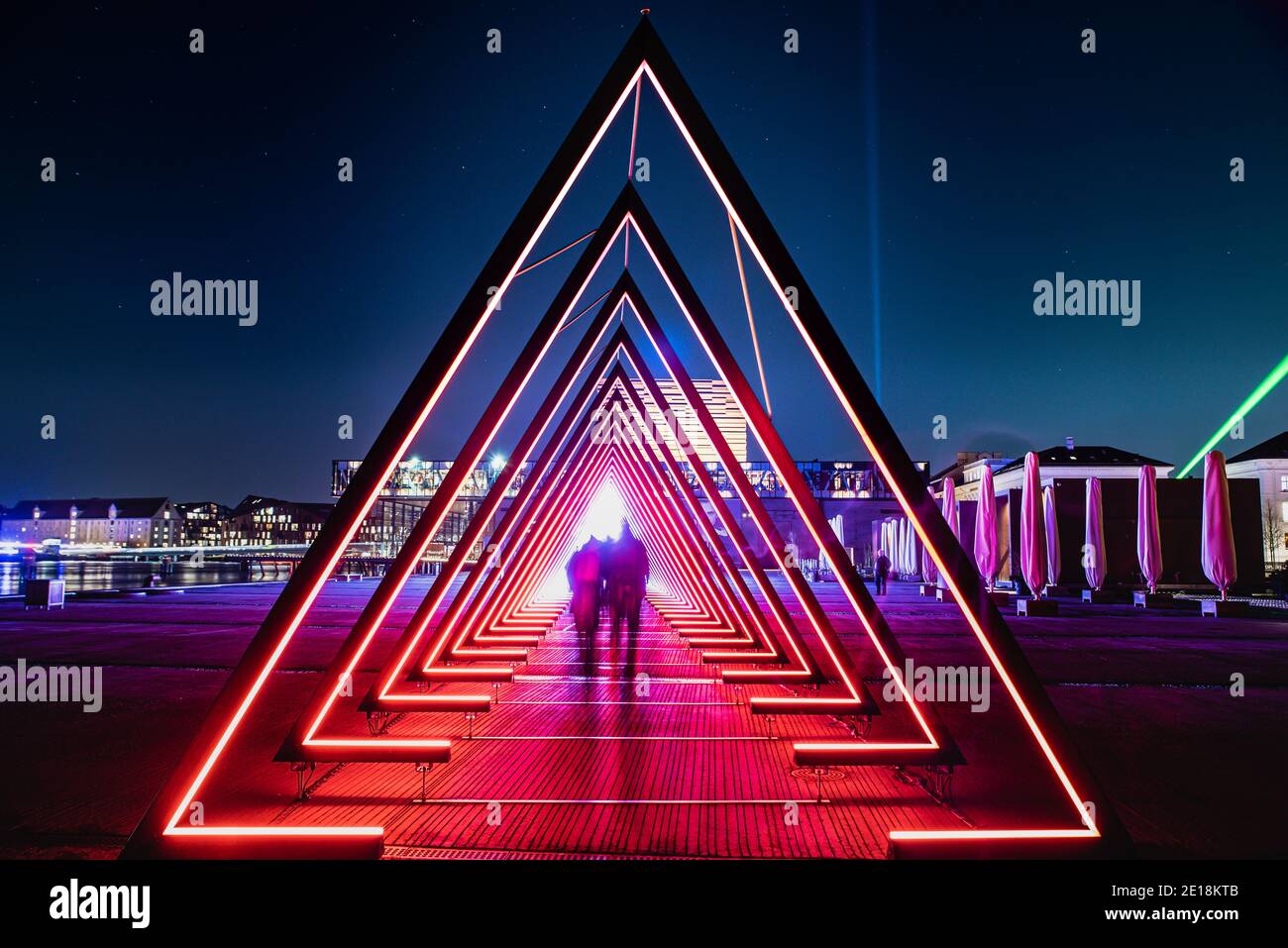 Tunnel luminoso o cancello di luce consiste di molti cancelli illuminati da luci luminose. Le persone offuscate appaiono come un'invasione aliena mentre le stelle sono visibili di notte Foto Stock