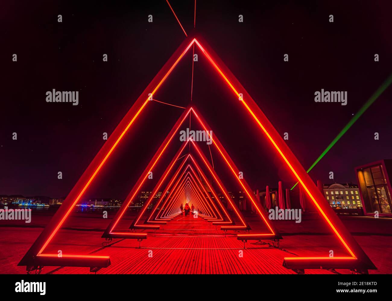 Cancelli di luce o luce rossa intensa installazione tunnel consiste di una successione di cancelli dove le persone sfocate guardano attraverso un mondo extraterrestre Foto Stock