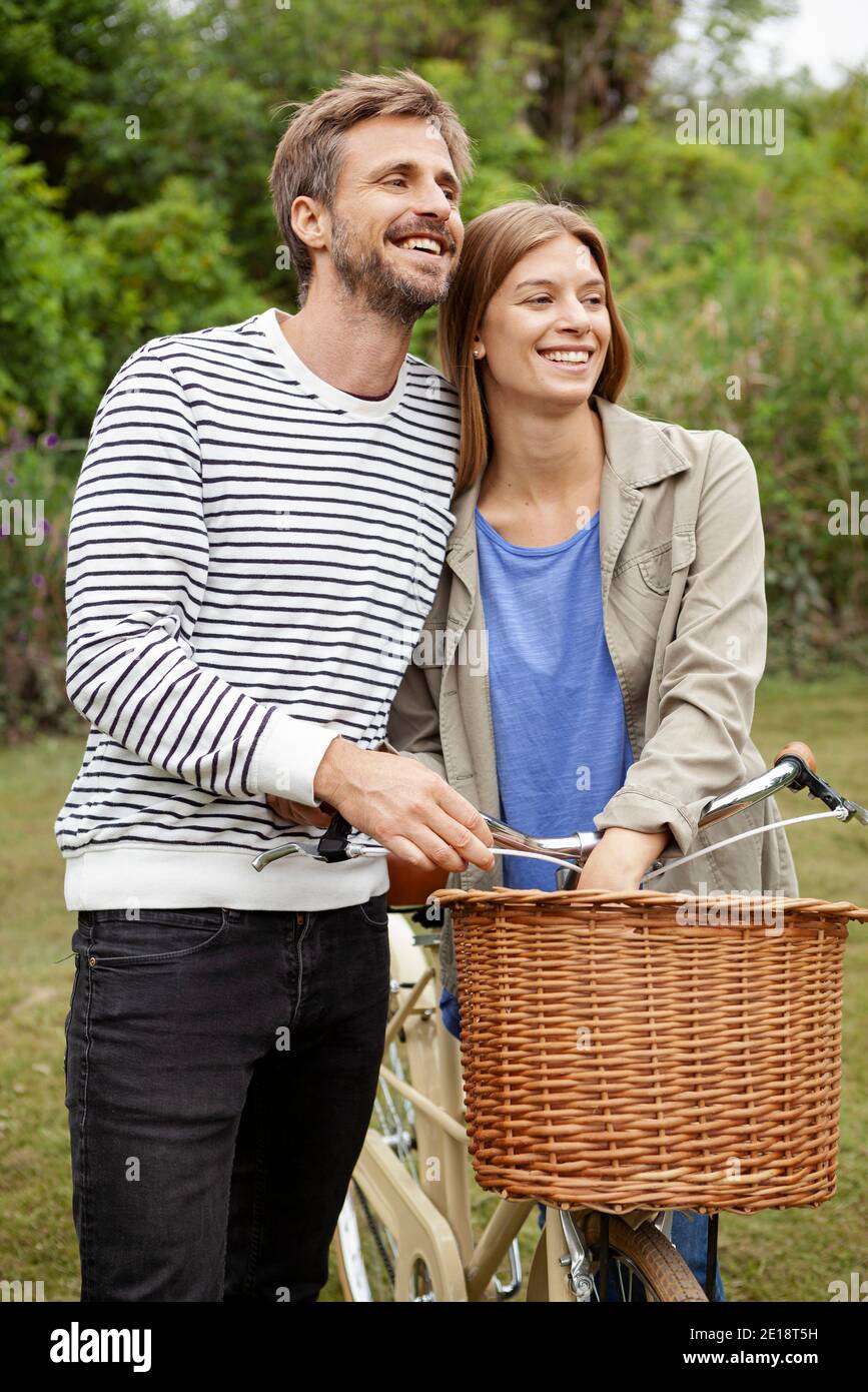 Una coppia di medie adulti sorridente che guarda via Foto Stock