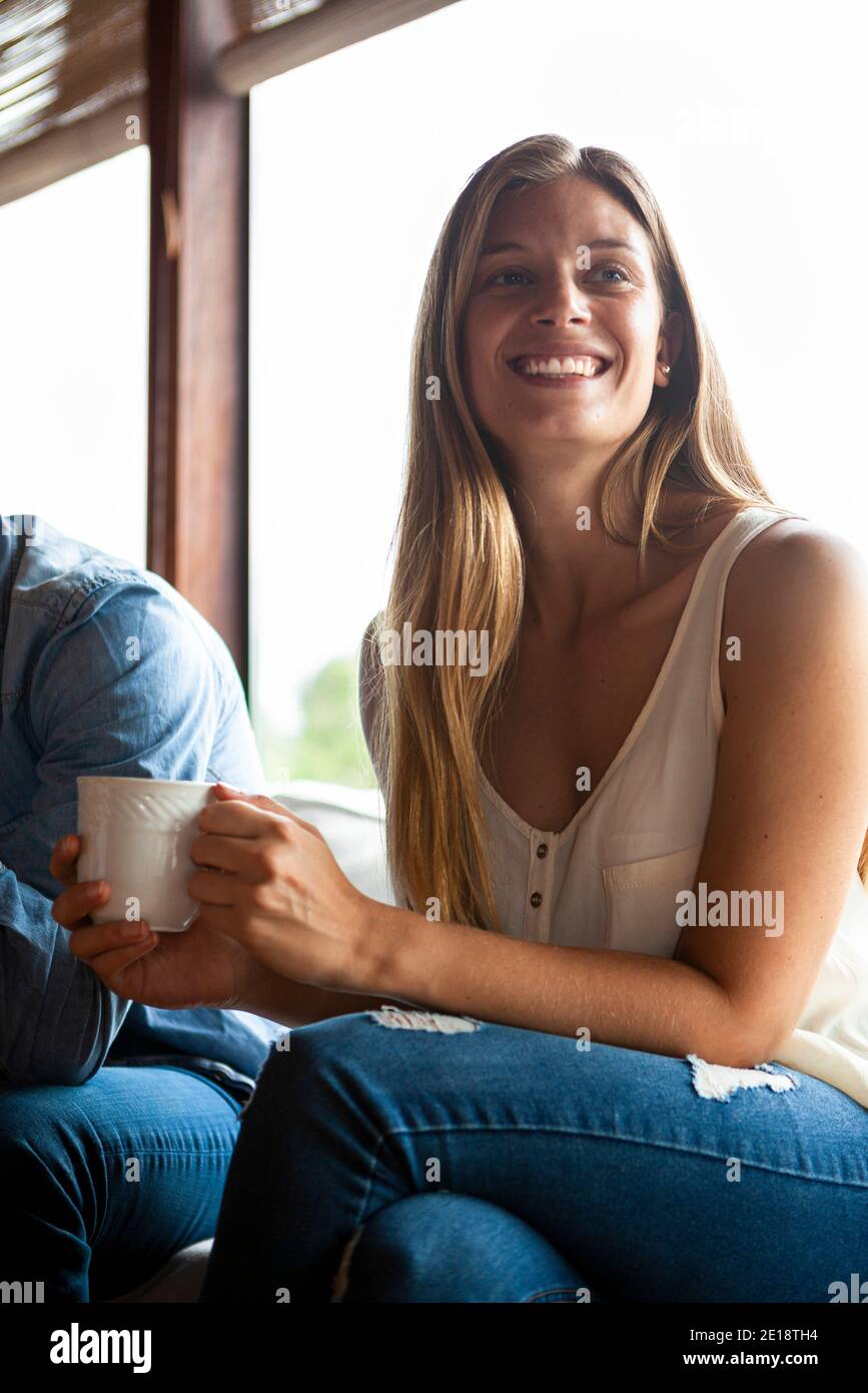 Donna mid adulta sorridente che ha caffè Foto Stock